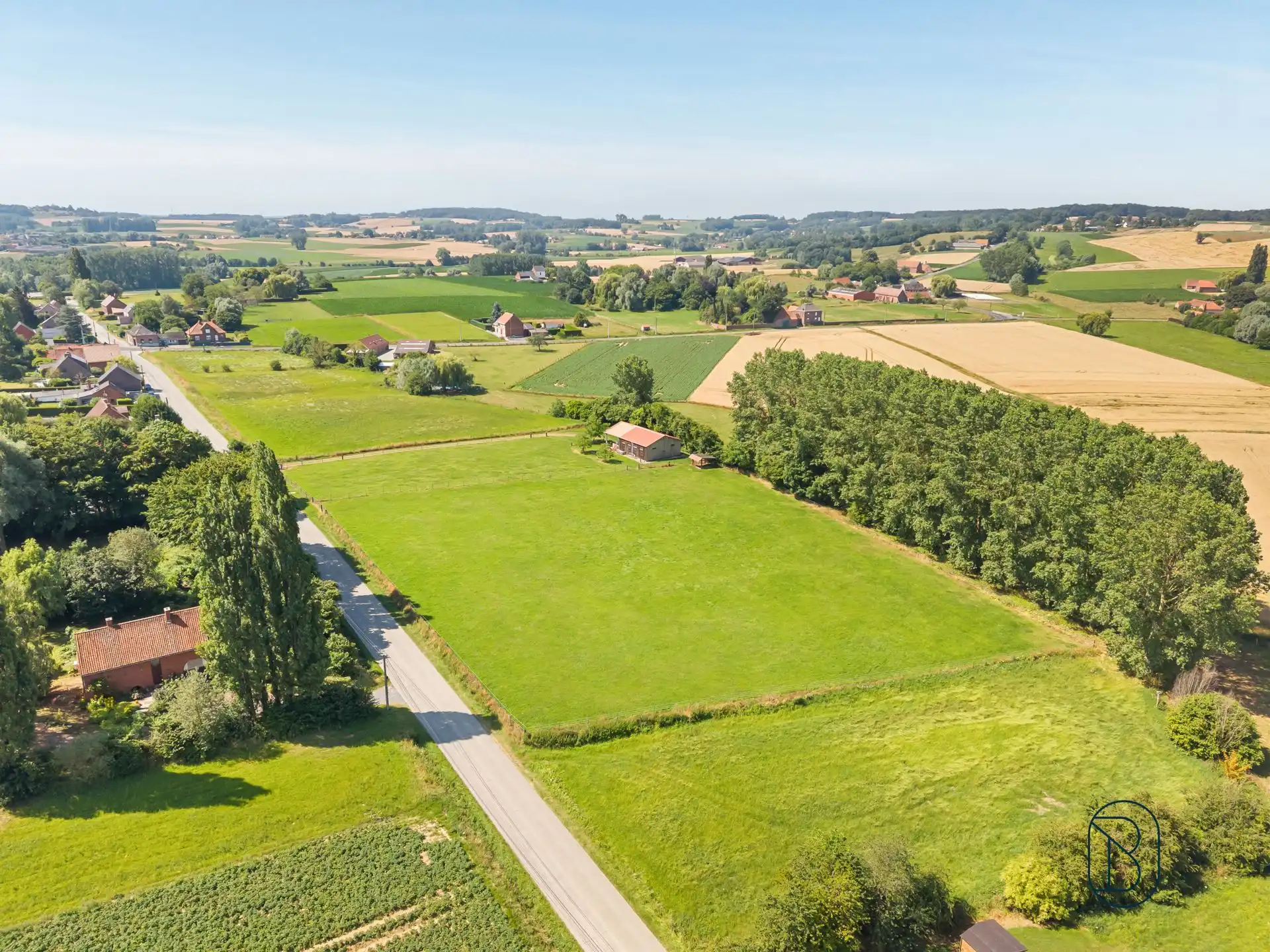 Volledig omheinde weide met grote paardenstalling foto {{pictureIndex}}