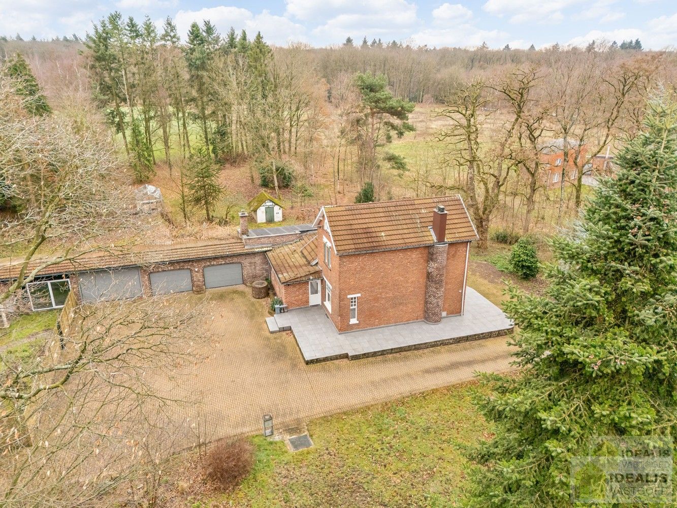 IDEALIS VASTGOED – Ruime te renoveren villa op riant perceel! De villa omvat 198m² netto bewoonbare oppervlakte met een ruime woonkamer en aansluitend uitgeruste keuken, badkamer, 2 grote en 1 kleine slaapkamer, kelder, veranda en 2 garages met sectionale poort van ca. 100m². De villa is gelegen op een prachtig perceel met een oppervlakte van ca. 1,1 hectare (11.000m²)! omgeven door bosgebied! Zeer geschikt voor kandidaten op zoek naar een unieke locatie zeer centraal gelegen, doch volledig omgeven door groen. foto 4