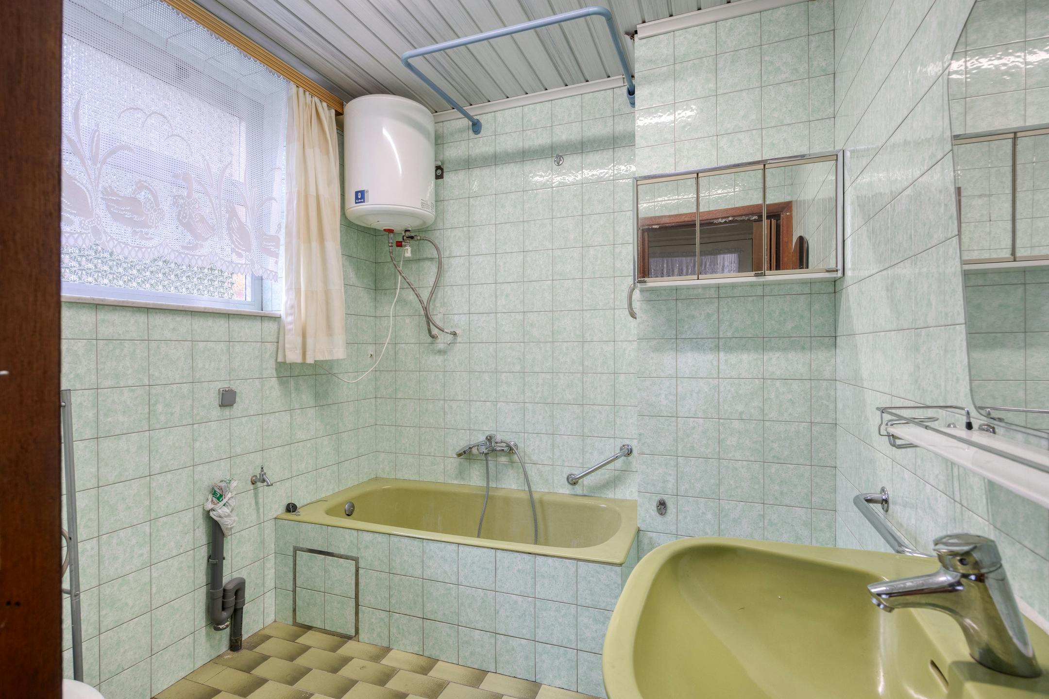 Te renoveren woning met zonnige tuin in Genk foto 8