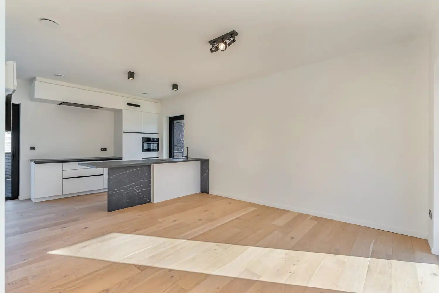 Deze stijlvolle nieuwbouw rijwoning in de Kanunnik Darisstraat combineert een centrale ligging in het hart van Borgloon met hedendaags wooncomfort en energiezuinige technieken. Met winkels, horeca en andere voorzieningen op wandelafstand woon je hier rustig én praktisch.  De woning is verdeeld over twee verdiepen en biedt een doordachte, gezinsvriendelijke indeling. Op het gelijkvloers bevindt zich een gezellige leefruimte met warme parketvloer, die naadloos aansluit op de volledig ingerichte leefkeuken met kookeiland – de ideale plek om te koken, te tafelen en gasten te ontvangen in een aangename, open sfeer.  Op de verdieping zijn er drie volwaardige slaapkamers, waardoor deze woning ideaal is voor gezinnen, koppels die extra ruimte wensen of wie een aparte bureau‑ of hobbykamer zoekt. De stijlvol afgewerkte badkamer, met kwalitatief badkamermeubel, ruime inloopdouche en moderne zwarte accenten, zorgt elke dag opnieuw voor een echt wellnessgevoel.  Buiten geniet je van een... foto 3