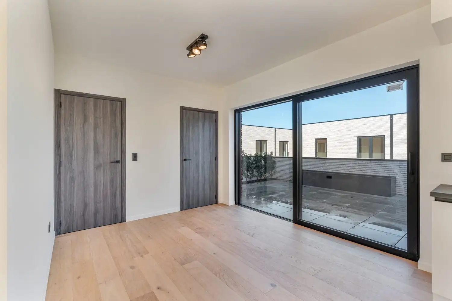 Deze stijlvolle nieuwbouw rijwoning in de Kanunnik Darisstraat combineert een centrale ligging in het hart van Borgloon met hedendaags wooncomfort en energiezuinige technieken. Met winkels, horeca en andere voorzieningen op wandelafstand woon je hier rustig én praktisch.  De woning is verdeeld over twee verdiepen en biedt een doordachte, gezinsvriendelijke indeling. Op het gelijkvloers bevindt zich een gezellige leefruimte met warme parketvloer, die naadloos aansluit op de volledig ingerichte leefkeuken met kookeiland – de ideale plek om te koken, te tafelen en gasten te ontvangen in een aangename, open sfeer.  Op de verdieping zijn er drie volwaardige slaapkamers, waardoor deze woning ideaal is voor gezinnen, koppels die extra ruimte wensen of wie een aparte bureau‑ of hobbykamer zoekt. De stijlvol afgewerkte badkamer, met kwalitatief badkamermeubel, ruime inloopdouche en moderne zwarte accenten, zorgt elke dag opnieuw voor een echt wellnessgevoel.  Buiten geniet je van een... foto 7