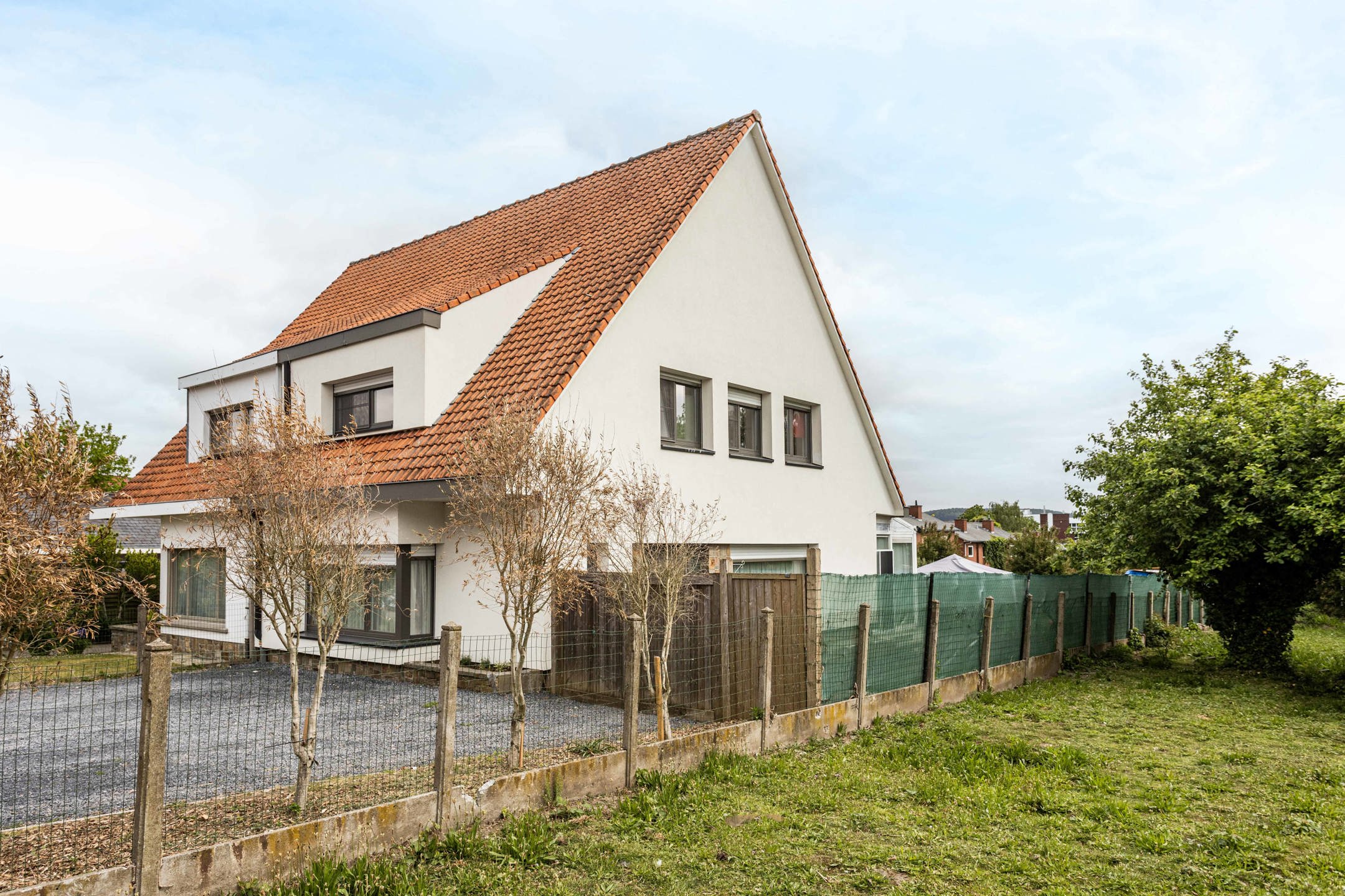 Hoofdfoto van de publicatie: Instapklare halfopen bebouwing met tuin, oprit & garage!