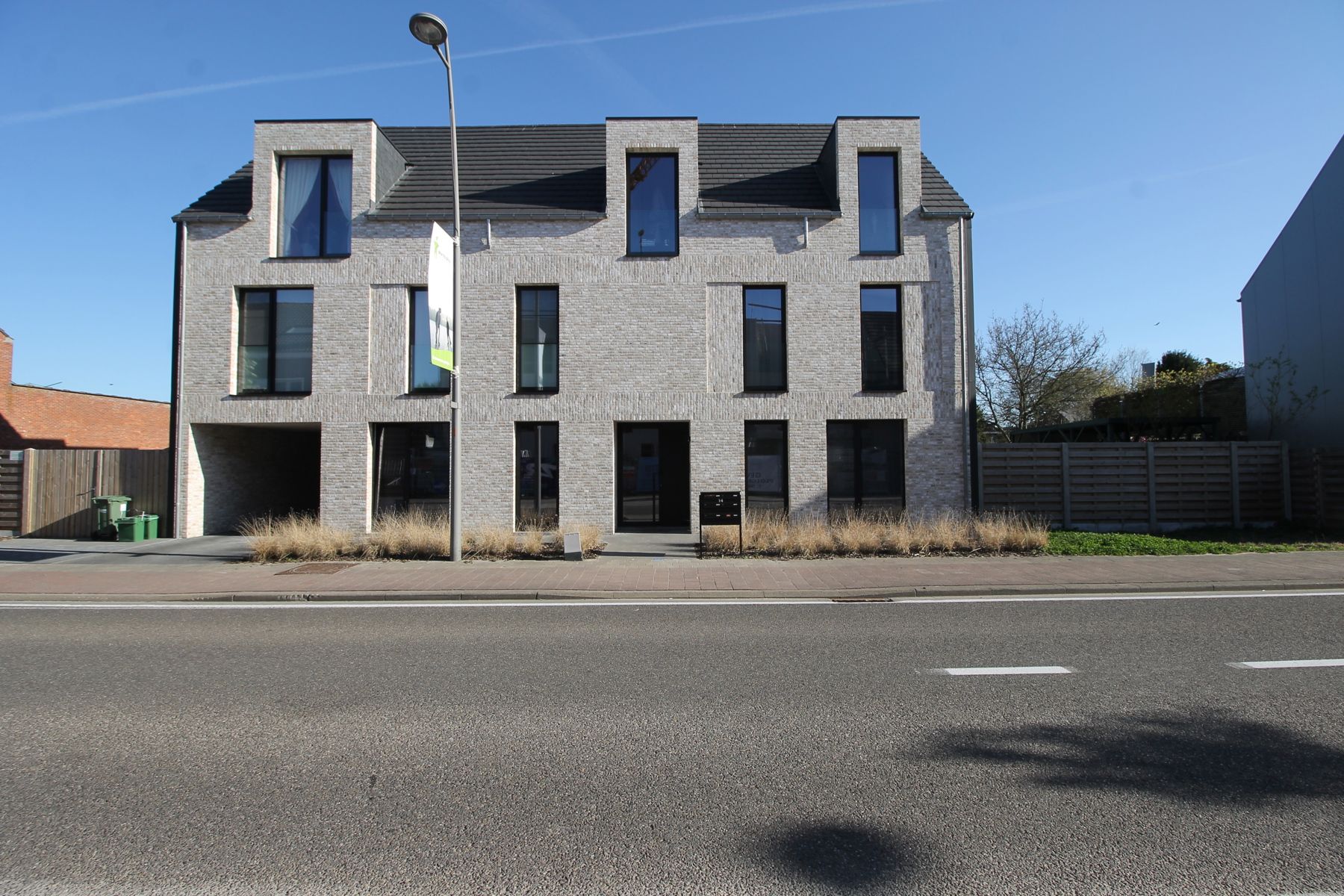Energiezuinig gelijkvloers nieuwbouwappartement rechts met tuin, terras, autostaanplaats en garage. foto {{pictureIndex}}