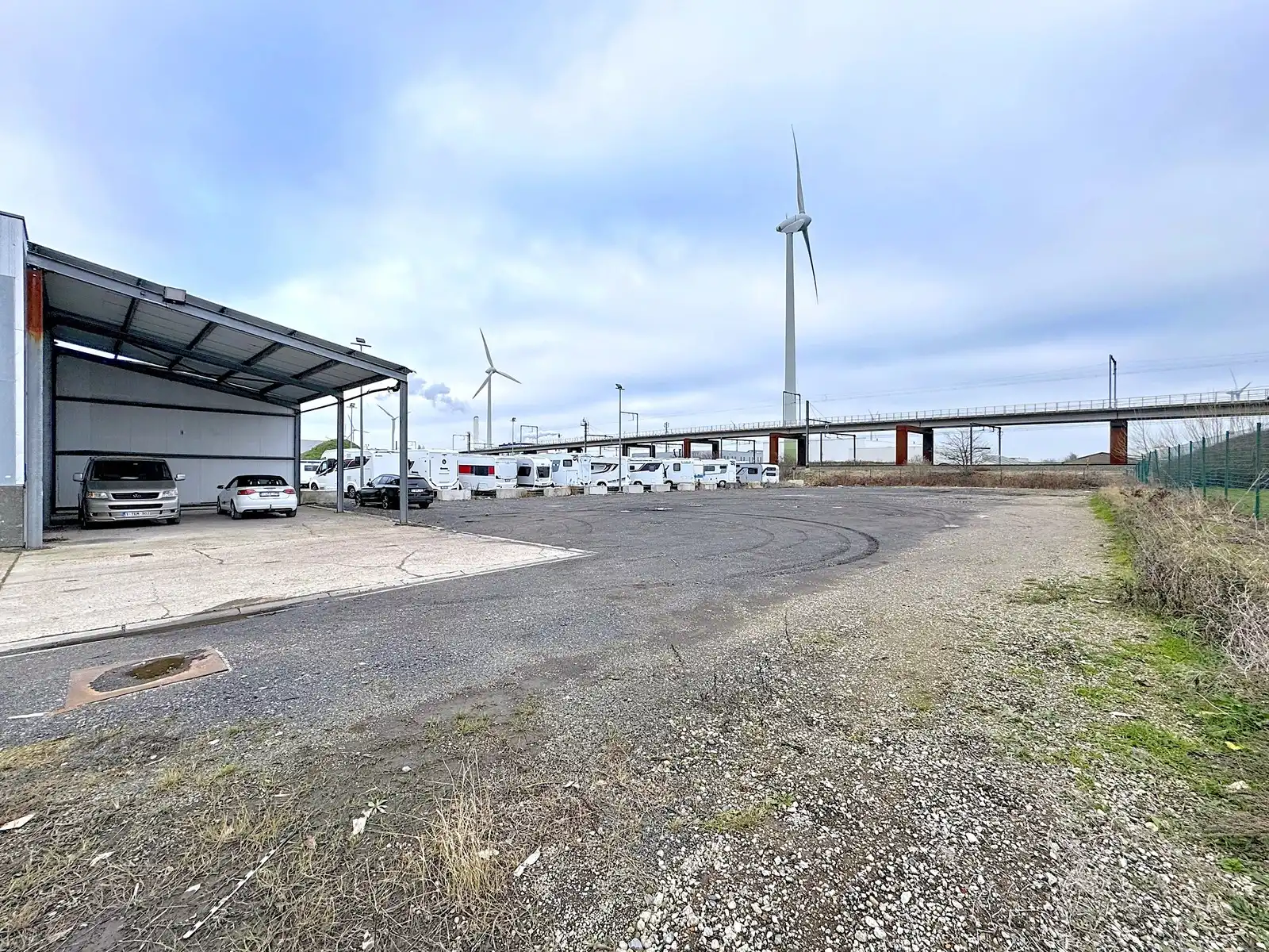 Verhard perceel INDUSTRIEGROND (± 1.800m2) met OVERKAPPING te huur op bedrijventerrein "Blauwe Toren" te Brugge. Volledig omheind en afgesloten aan de openbare weg! foto 2