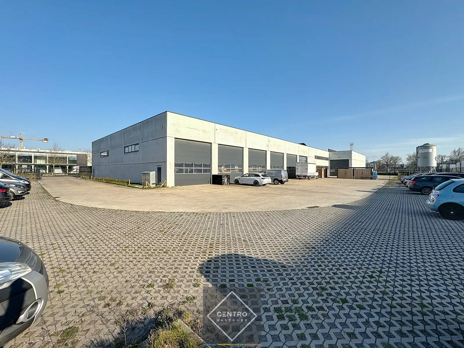 Goed geïsoleerd en verwarmd BEDRIJFSGEBOUW, bestaande uit MAGAZIJNEN (1.080m²) met KANTOREN en randaccomodatie (999m²) en 40-tal private parkeerplaatsen op het terrein. Vlak aan de afrit Zandvoorde (Oostende). foto 3