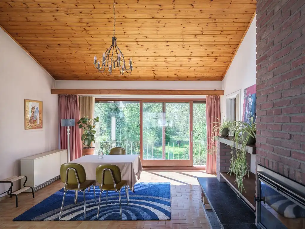 Hoofdfoto van de publicatie: Mid-century modern villa met vier slaapkamers, verdeeld over drie niveaus, gelegen op een groen perceel in Lievegem.