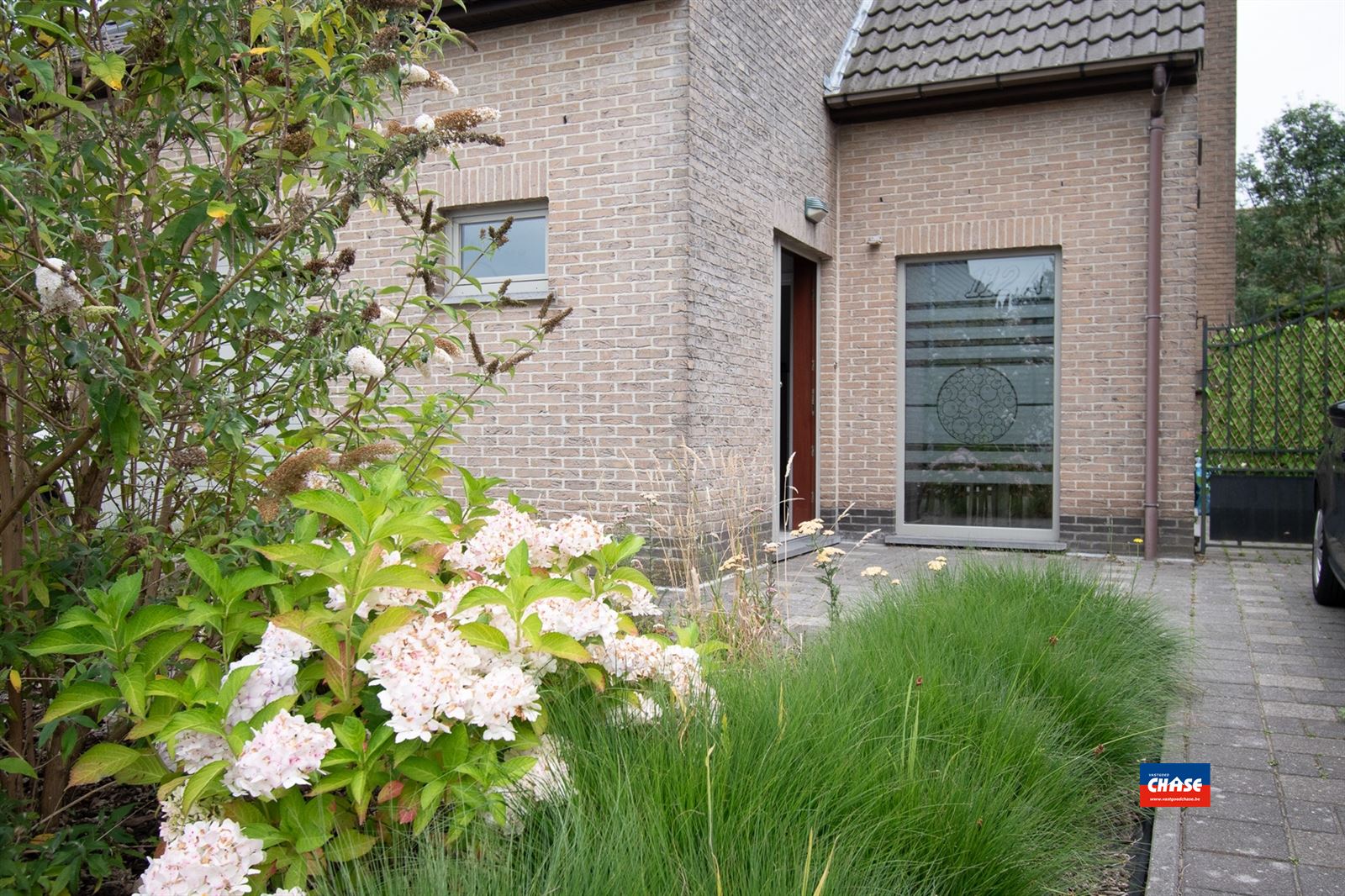 Recente, halfopen woning met drie slaapkamers, grote zonnige tuin, garage en drie opritten foto 2