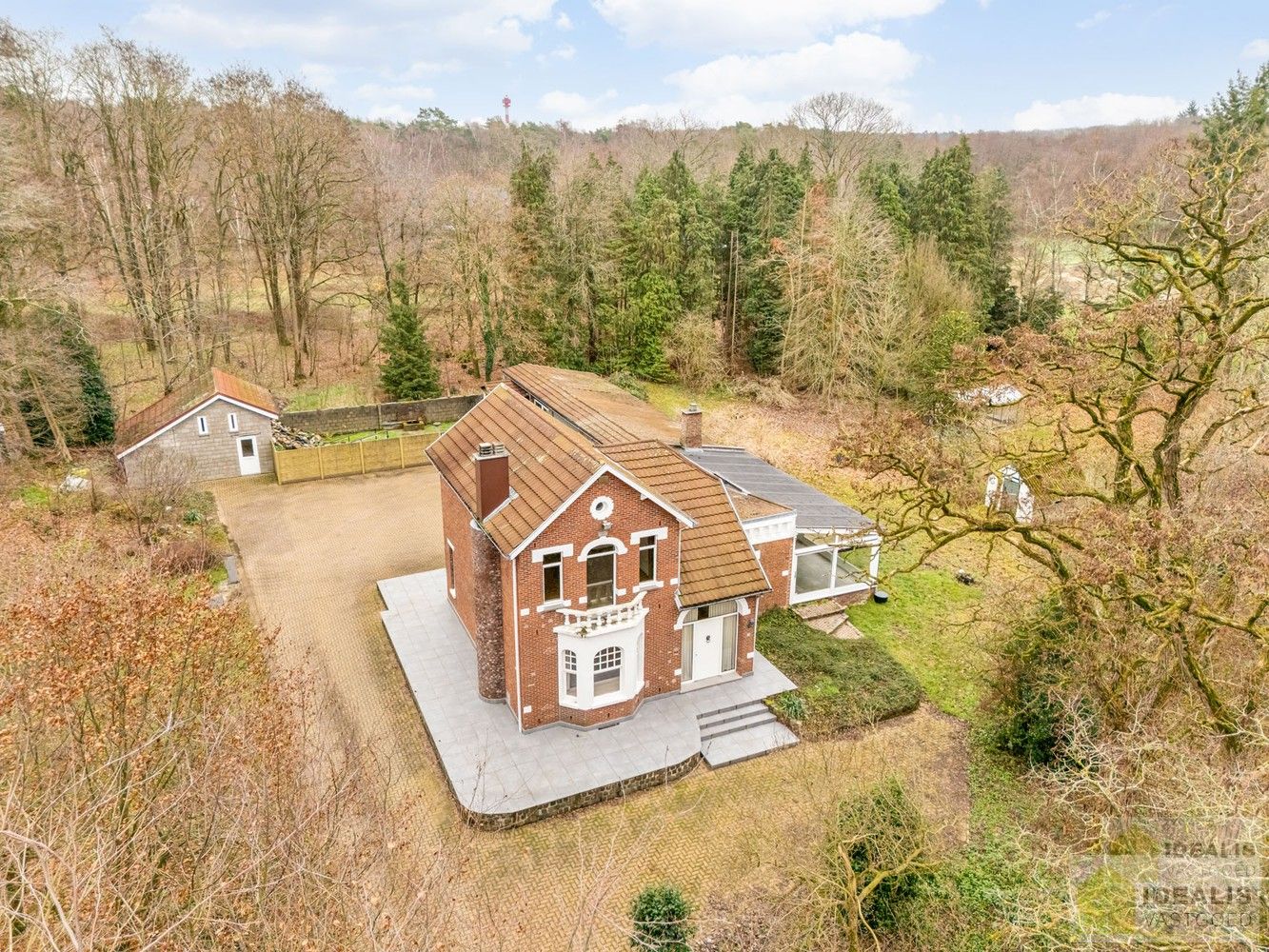 IDEALIS VASTGOED – Ruime te renoveren villa op riant perceel! De villa omvat 198m² netto bewoonbare oppervlakte met een ruime woonkamer en aansluitend uitgeruste keuken, badkamer, 2 grote en 1 kleine slaapkamer, kelder, veranda en 2 garages met sectionale poort van ca. 100m². De villa is gelegen op een prachtig perceel met een oppervlakte van ca. 1,1 hectare (11.000m²)! omgeven door bosgebied! Zeer geschikt voor kandidaten op zoek naar een unieke locatie zeer centraal gelegen, doch volledig omgeven door groen. foto 2