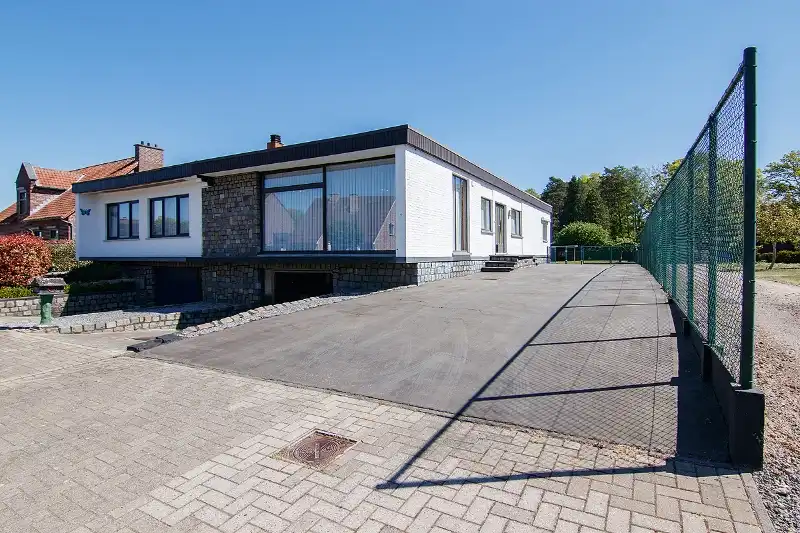 Hoofdfoto van de publicatie: Ruime en rustig gelegen, te renoveren gelijkvloerse woning met bijna volledige onderkeldering op een knap perceel