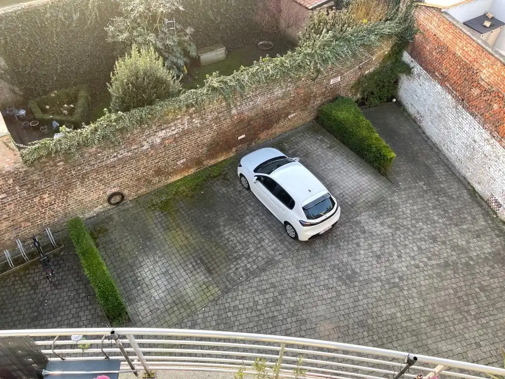 Kristus Koning      AUTOSTAANPLAATS in open lucht afgesloten van de straat ( op achterliggende grond van een appartementsgebouw  Res. Veldmaarschalk Foch)in foto 2