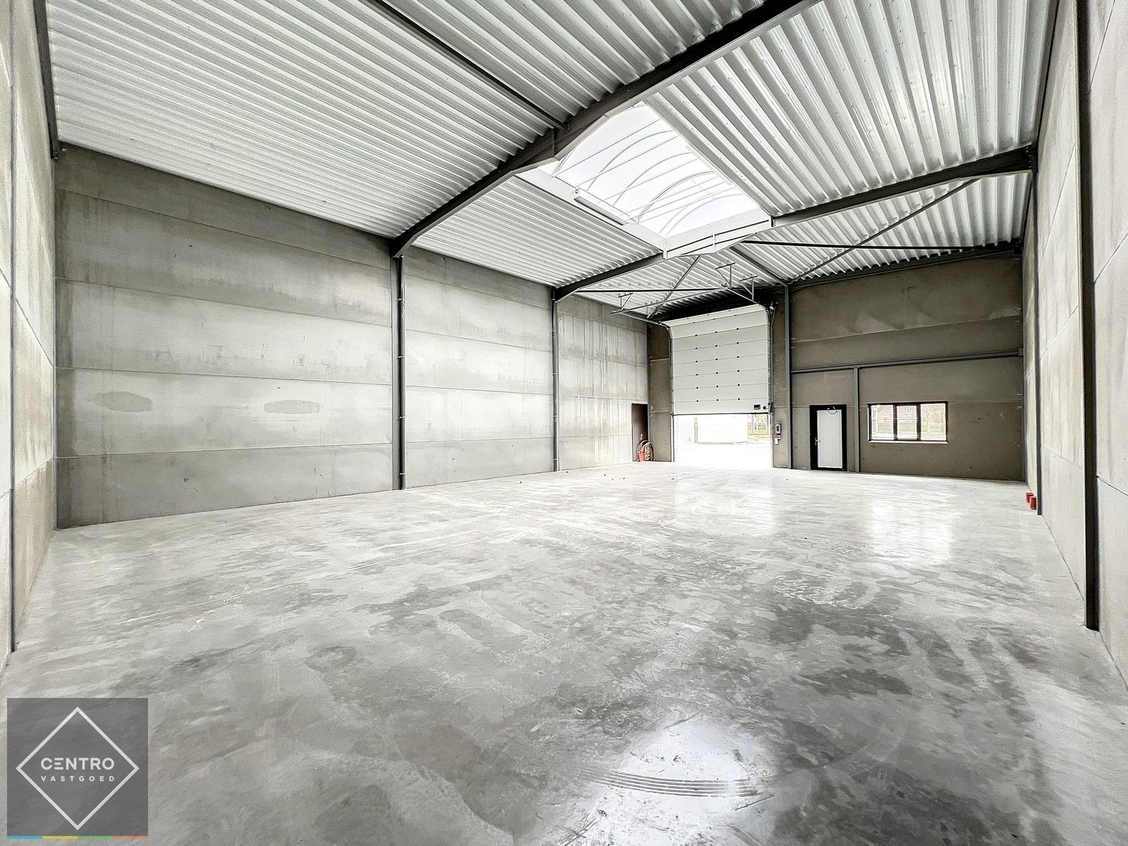 Kwalitatief en goed geïsoleerd NB MAGAZIJN (265m2), voorzien van elektrische sectionaalpoort, deur, raam (voor kantoor) en 2 private parkeerplaatsen op industriezone te Waregem. foto 2
