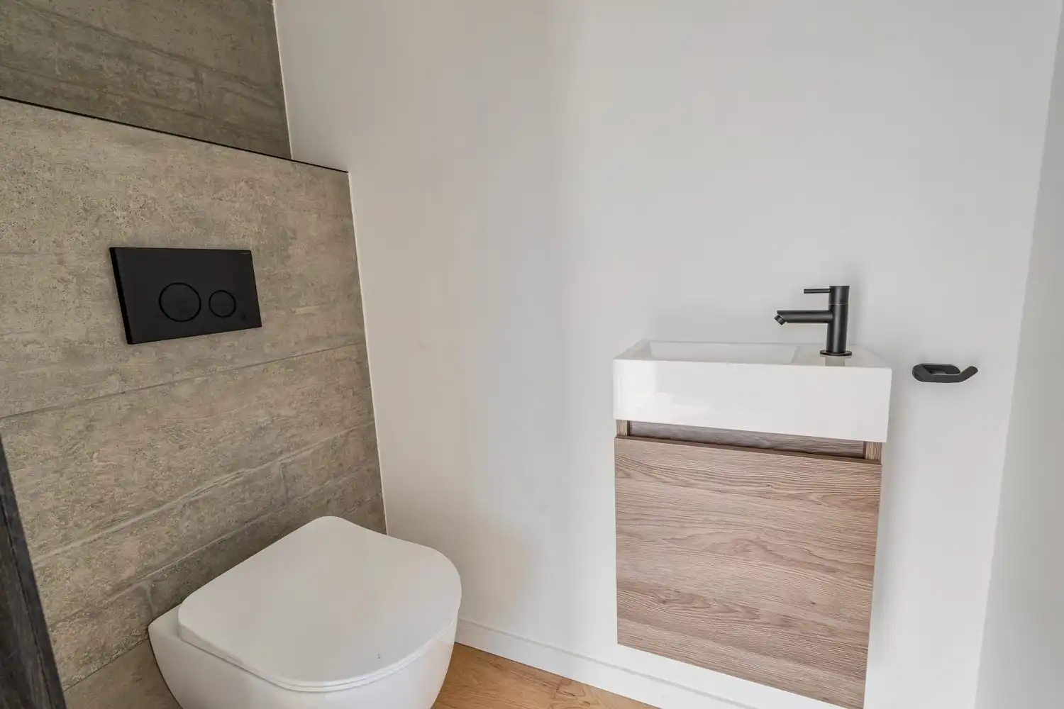 Deze stijlvolle nieuwbouw rijwoning in de Kanunnik Darisstraat combineert een centrale ligging in het hart van Borgloon met hedendaags wooncomfort en energiezuinige technieken. Met winkels, horeca en andere voorzieningen op wandelafstand woon je hier rustig én praktisch.  De woning is verdeeld over twee verdiepen en biedt een doordachte, gezinsvriendelijke indeling. Op het gelijkvloers bevindt zich een gezellige leefruimte met warme parketvloer, die naadloos aansluit op de volledig ingerichte leefkeuken met kookeiland – de ideale plek om te koken, te tafelen en gasten te ontvangen in een aangename, open sfeer.  Op de verdieping zijn er drie volwaardige slaapkamers, waardoor deze woning ideaal is voor gezinnen, koppels die extra ruimte wensen of wie een aparte bureau‑ of hobbykamer zoekt. De stijlvol afgewerkte badkamer, met kwalitatief badkamermeubel, ruime inloopdouche en moderne zwarte accenten, zorgt elke dag opnieuw voor een echt wellnessgevoel.  Buiten geniet je van een... foto 18