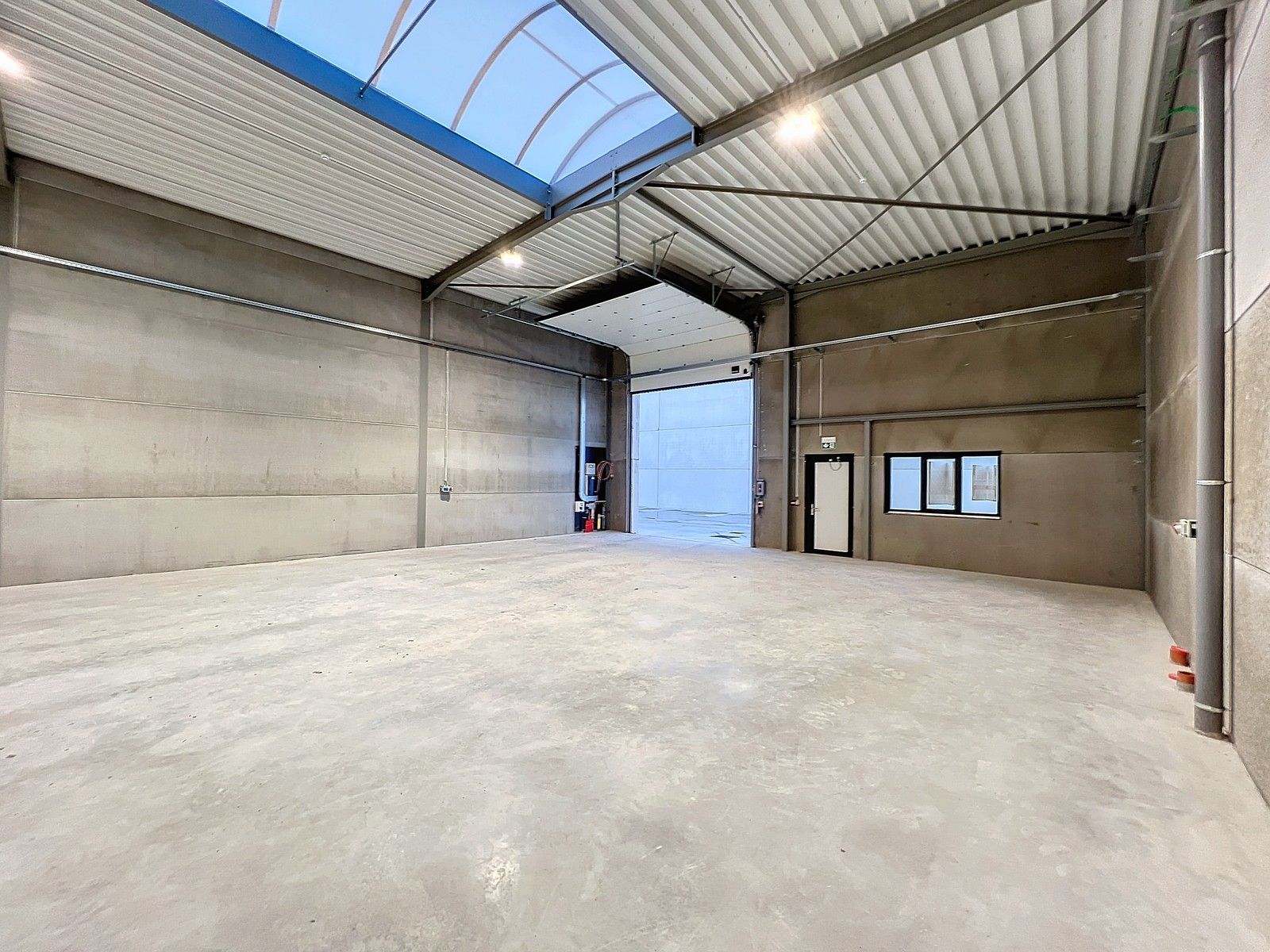 Kwalitatief en goed geïsoleerd NB MAGAZIJN (277m2), voorzien van elektrische sectionaalpoort, deur, raam (voor kantoor) en 2 private parkeerplaatsen op industriezone te Waregem. foto 4