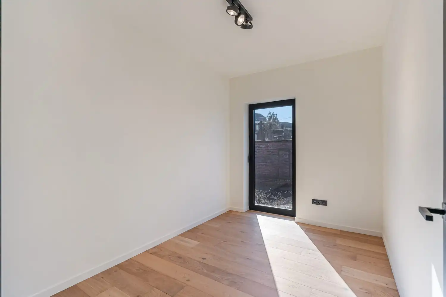 Deze stijlvolle nieuwbouw rijwoning in de Kanunnik Darisstraat combineert een centrale ligging in het hart van Borgloon met hedendaags wooncomfort en energiezuinige technieken. Met winkels, horeca en andere voorzieningen op wandelafstand woon je hier rustig én praktisch.  De woning is verdeeld over twee verdiepen en biedt een doordachte, gezinsvriendelijke indeling. Op het gelijkvloers bevindt zich een gezellige leefruimte met warme parketvloer, die naadloos aansluit op de volledig ingerichte leefkeuken met kookeiland – de ideale plek om te koken, te tafelen en gasten te ontvangen in een aangename, open sfeer.  Op de verdieping zijn er drie volwaardige slaapkamers, waardoor deze woning ideaal is voor gezinnen, koppels die extra ruimte wensen of wie een aparte bureau‑ of hobbykamer zoekt. De stijlvol afgewerkte badkamer, met kwalitatief badkamermeubel, ruime inloopdouche en moderne zwarte accenten, zorgt elke dag opnieuw voor een echt wellnessgevoel.  Buiten geniet je van een... foto 12