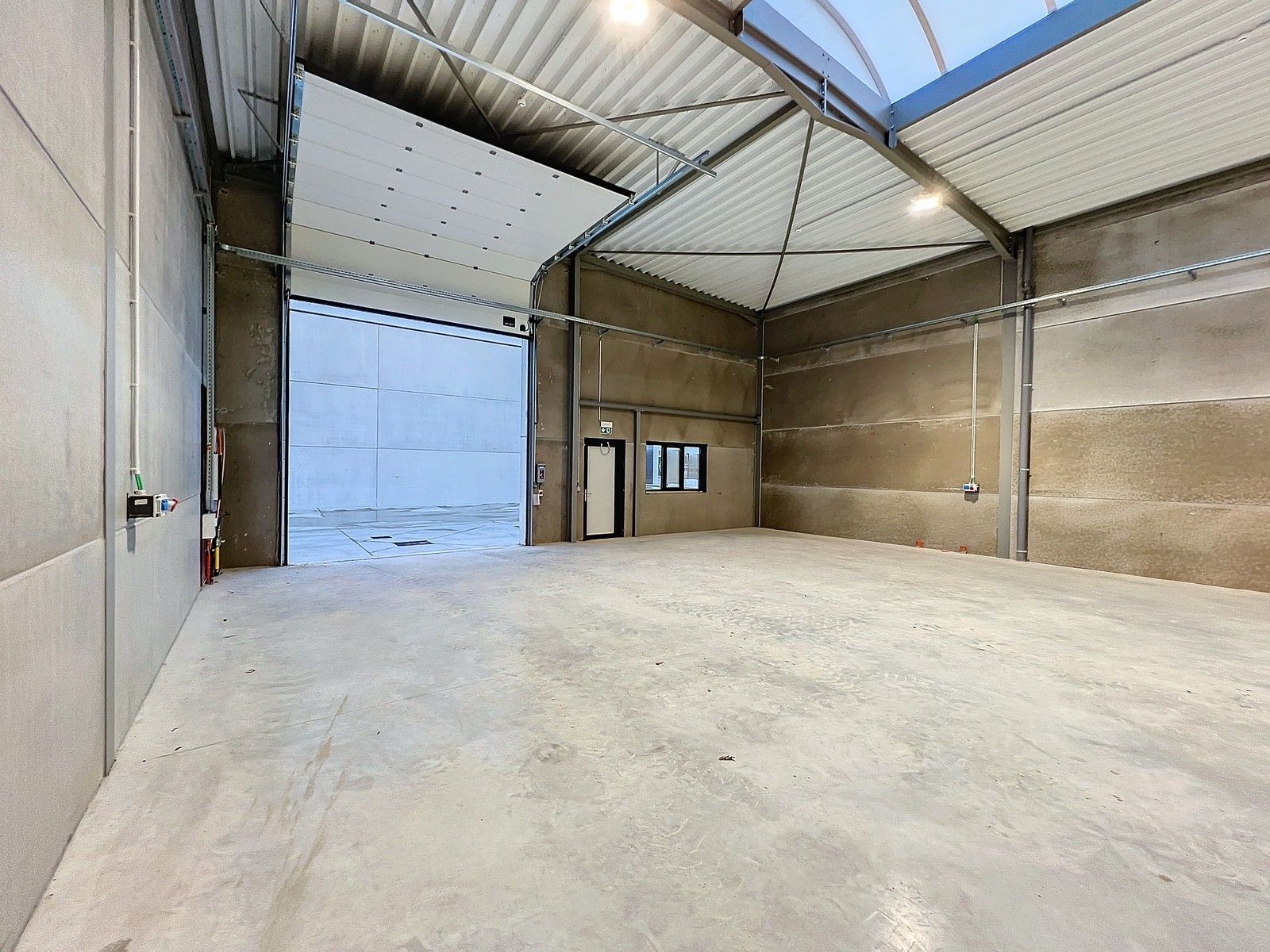 Kwalitatief en goed geïsoleerd NB MAGAZIJN (277m2), voorzien van elektrische sectionaalpoort, deur, raam (voor kantoor) en 2 private parkeerplaatsen op industriezone te Waregem. foto 6
