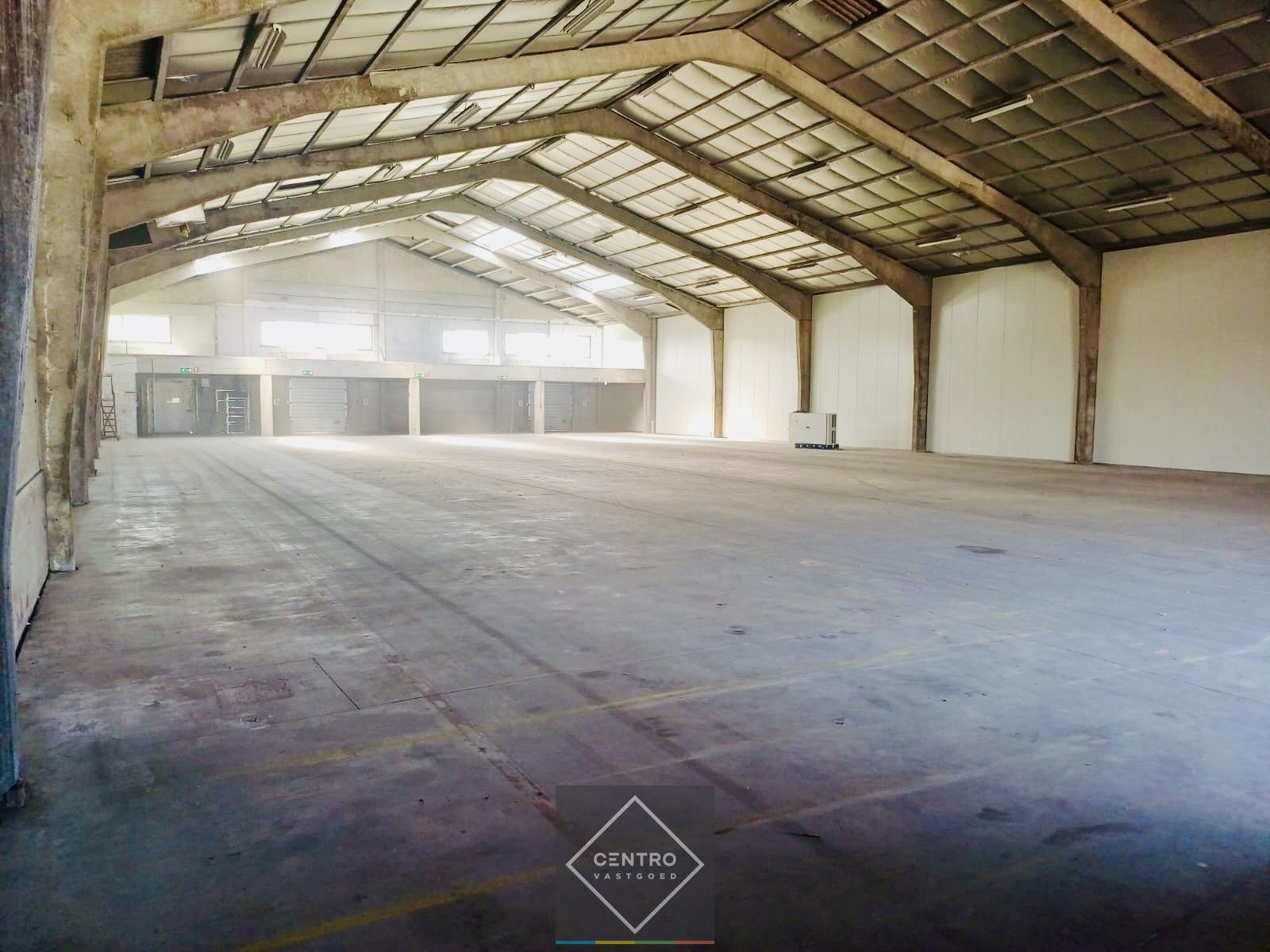 Instapklaar MAGAZIJN (1.200m²), voorzien van 2 LAADKADEN (met levellers), elektrische sectionaalpoort en verhard terrein (voor- en achterkant) op industriezone te Gistel. foto {{pictureIndex}}