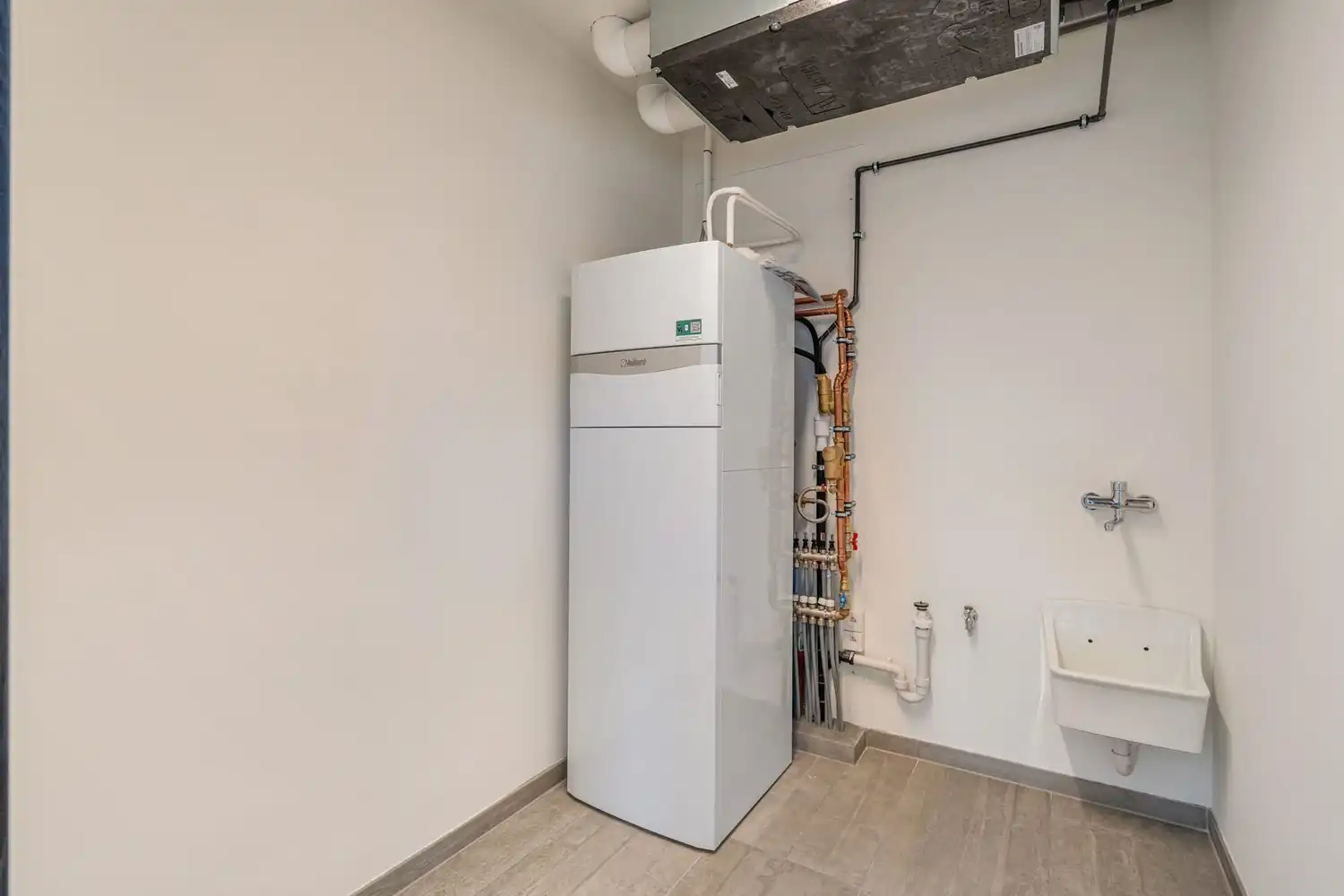 Deze stijlvolle nieuwbouw rijwoning in de Kanunnik Darisstraat combineert een centrale ligging in het hart van Borgloon met hedendaags wooncomfort en energiezuinige technieken. Met winkels, horeca en andere voorzieningen op wandelafstand woon je hier rustig én praktisch.  De woning is verdeeld over twee verdiepen en biedt een doordachte, gezinsvriendelijke indeling. Op het gelijkvloers bevindt zich een gezellige leefruimte met warme parketvloer, die naadloos aansluit op de volledig ingerichte leefkeuken met kookeiland – de ideale plek om te koken, te tafelen en gasten te ontvangen in een aangename, open sfeer.  Op de verdieping zijn er drie volwaardige slaapkamers, waardoor deze woning ideaal is voor gezinnen, koppels die extra ruimte wensen of wie een aparte bureau‑ of hobbykamer zoekt. De stijlvol afgewerkte badkamer, met kwalitatief badkamermeubel, ruime inloopdouche en moderne zwarte accenten, zorgt elke dag opnieuw voor een echt wellnessgevoel.  Buiten geniet je van een... foto 16