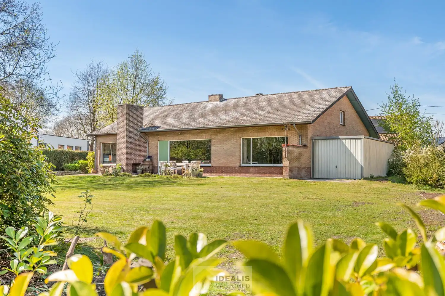 IDEALIS VASTGOED – Goed onderhouden en aangename gelijkvloerse woning met 2 slaapkamers op een prachtig, ruim en uiterst breed perceel foto {{pictureIndex}}