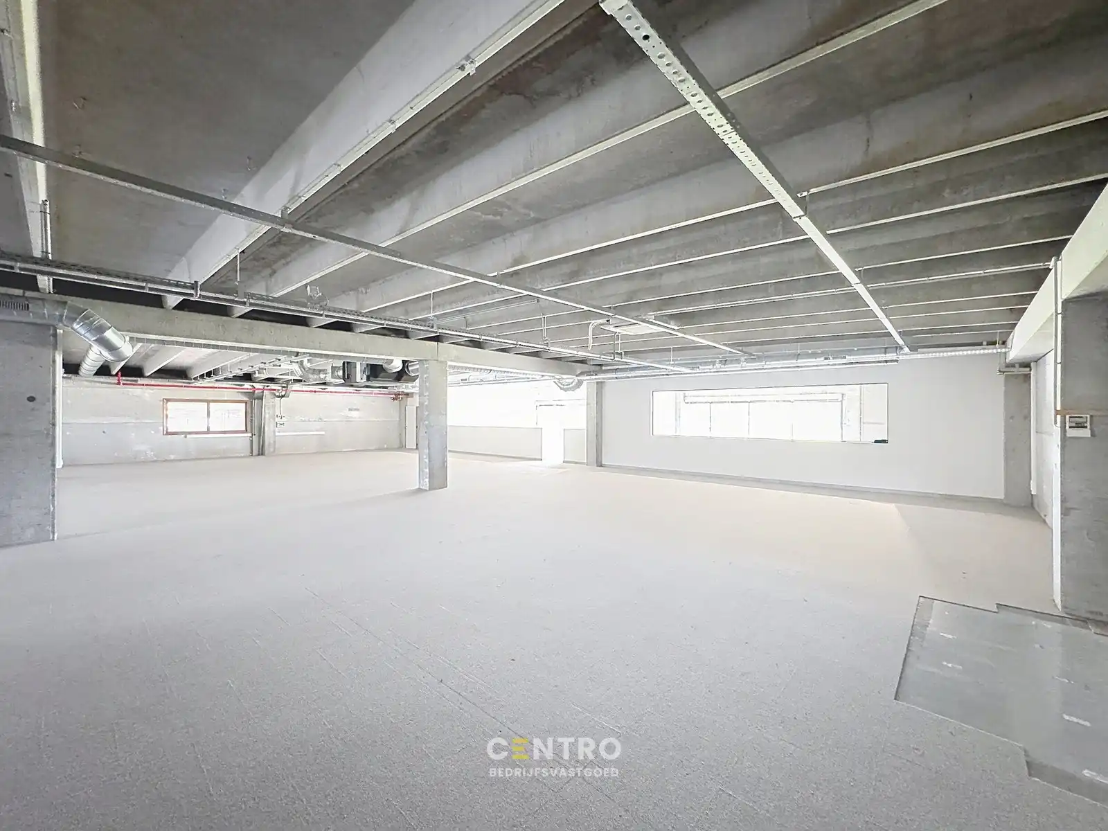 Goed geïsoleerd en verwarmd BEDRIJFSGEBOUW, bestaande uit MAGAZIJNEN (1.080m²) met KANTOREN en randaccomodatie (999m²) en 40-tal private parkeerplaatsen op het terrein. Vlak aan de afrit Zandvoorde (Oostende). foto 8