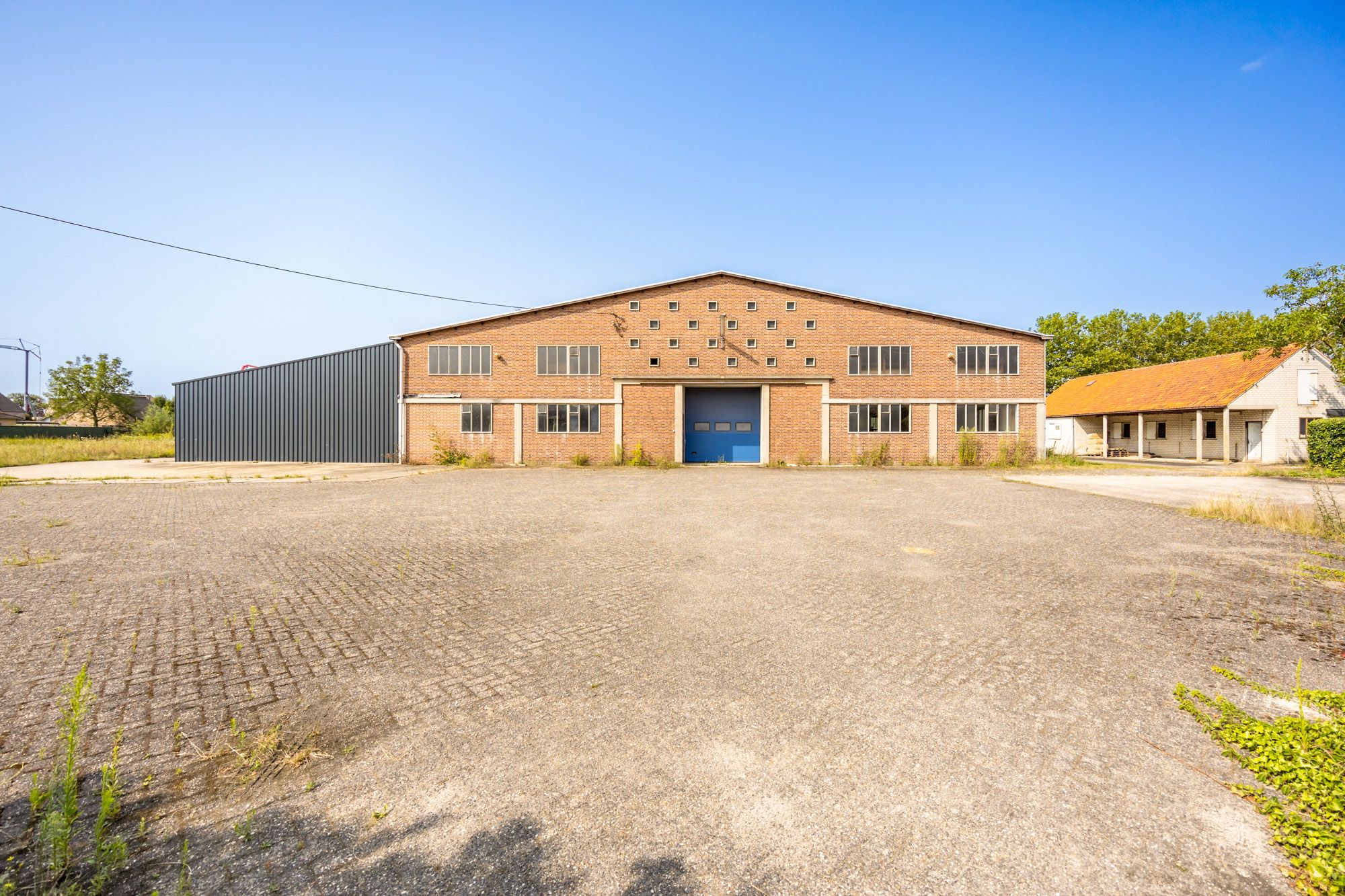 IDEALIS VASTGOED – Uiterst ruim perceel van maar liefst 89a 25ca met loods (+-700m²) met eindeloos veel mogelijkheden.  foto {{pictureIndex}}