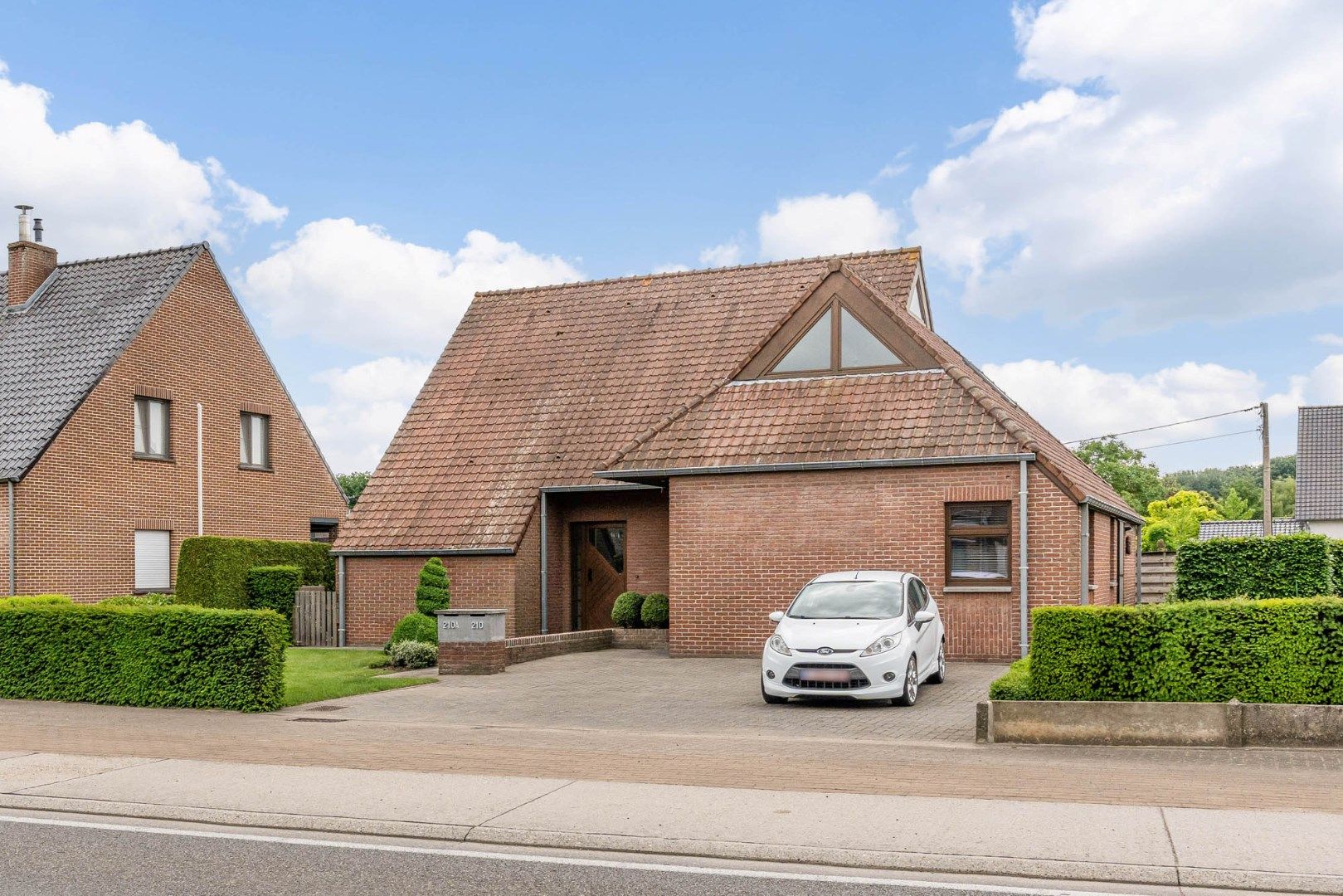 Hoofdfoto van de publicatie: Comfortabel gebouw, onderverdeeld in een gelijkvloers appartement en een woning (210 + 210A), op een perceel van 9a60 met diverse mogelijkheden (kangoeroewoning