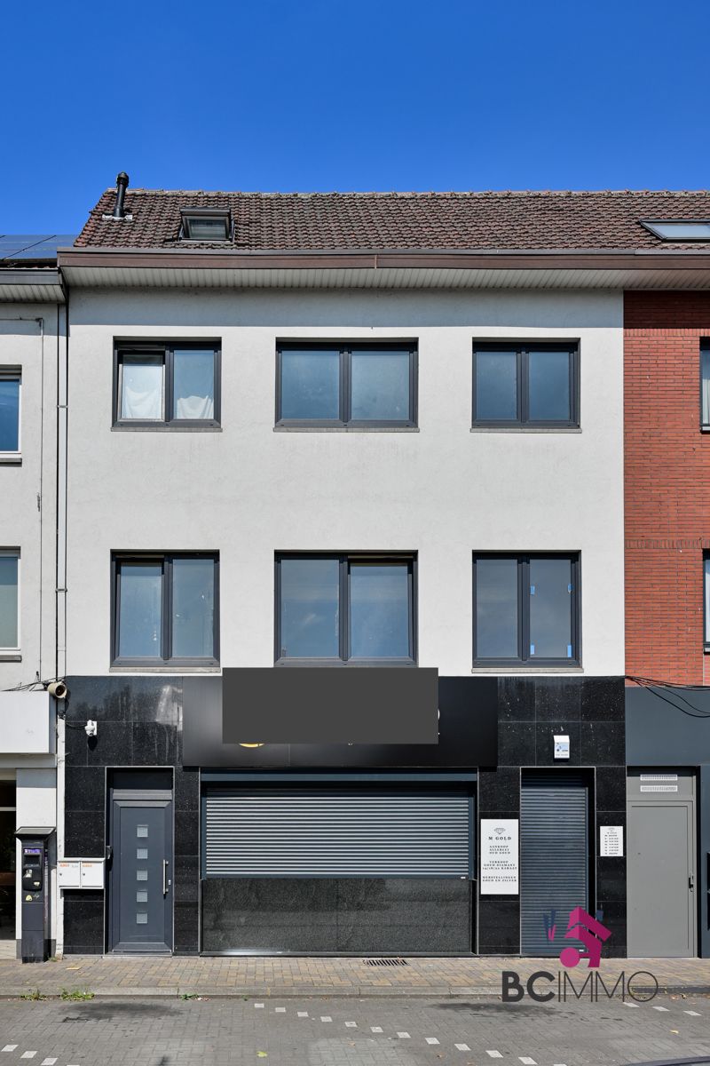 Pand met handelsruimte met woonst en een triplex appartement foto {{pictureIndex}}