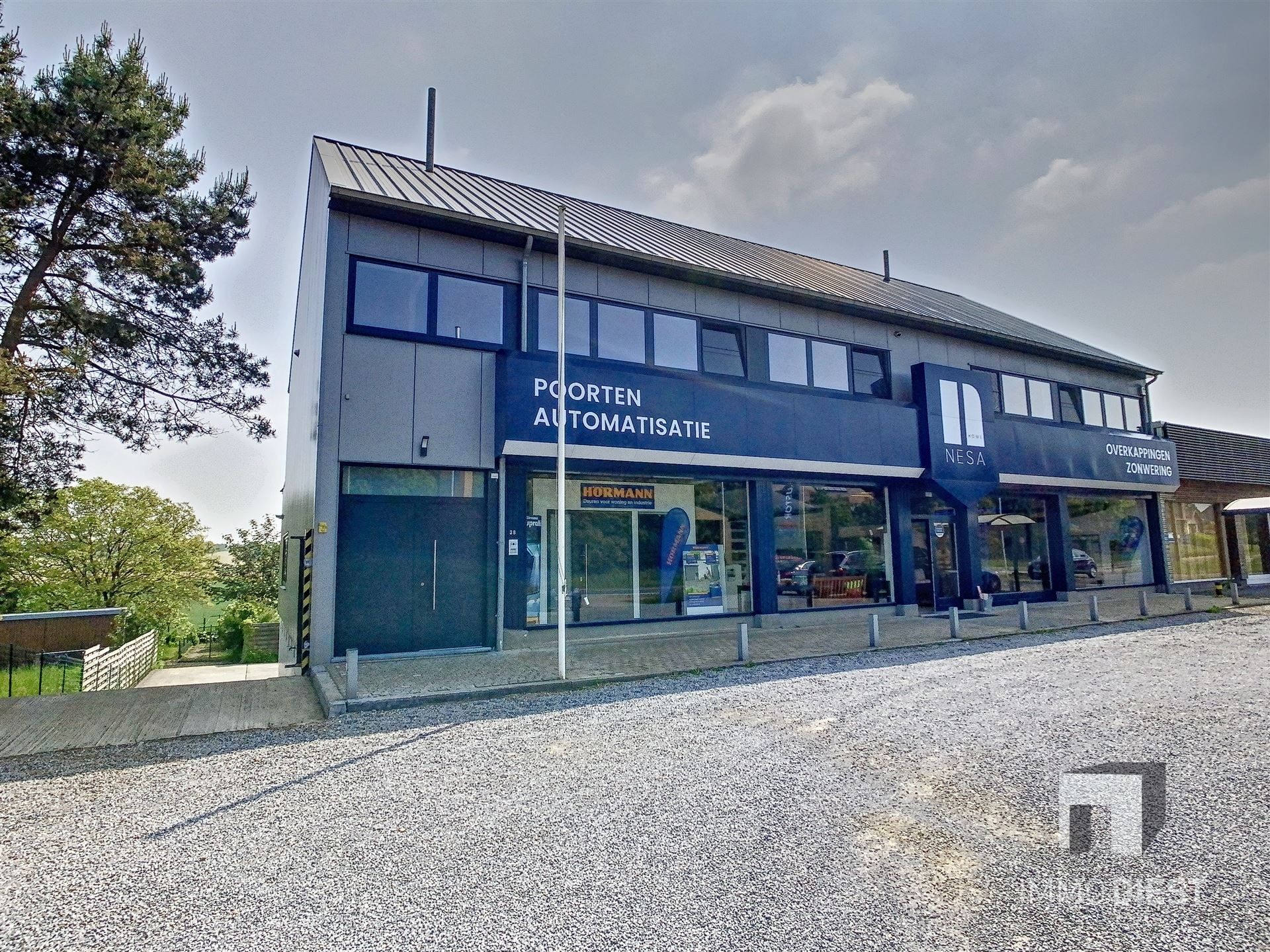 Toonzaal van ca 220m² met achterliggend magazijn (ca 185m²) & woonst op commerciële toplocatie! foto 1