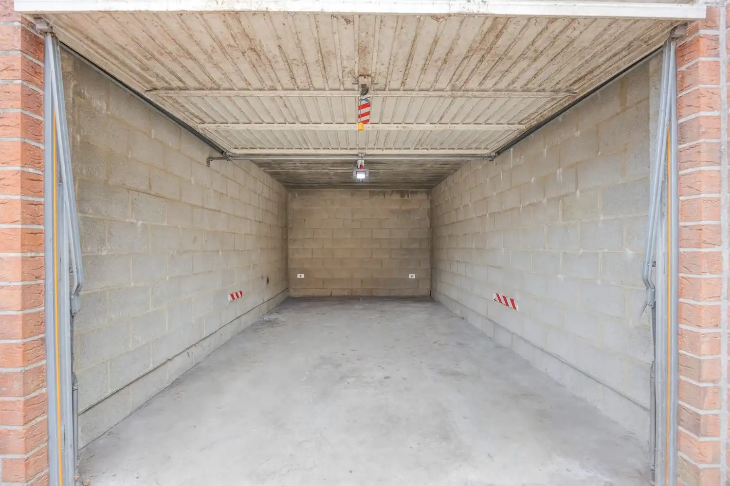 Afgesloten garagebox met automatische poort gelegen aan de achterzijde van het gebouw foto 24