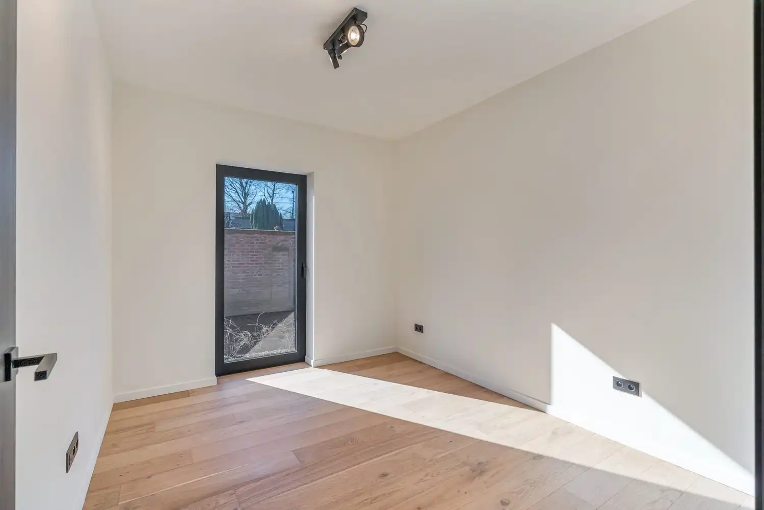 Deze stijlvolle nieuwbouw rijwoning in de Kanunnik Darisstraat combineert een centrale ligging in het hart van Borgloon met hedendaags wooncomfort en energiezuinige technieken. Met winkels, horeca en andere voorzieningen op wandelafstand woon je hier rustig én praktisch.  De woning is verdeeld over twee verdiepen en biedt een doordachte, gezinsvriendelijke indeling. Op het gelijkvloers bevindt zich een gezellige leefruimte met warme parketvloer, die naadloos aansluit op de volledig ingerichte leefkeuken met kookeiland – de ideale plek om te koken, te tafelen en gasten te ontvangen in een aangename, open sfeer.  Op de verdieping zijn er drie volwaardige slaapkamers, waardoor deze woning ideaal is voor gezinnen, koppels die extra ruimte wensen of wie een aparte bureau‑ of hobbykamer zoekt. De stijlvol afgewerkte badkamer, met kwalitatief badkamermeubel, ruime inloopdouche en moderne zwarte accenten, zorgt elke dag opnieuw voor een echt wellnessgevoel.  Buiten geniet je van een... foto 14