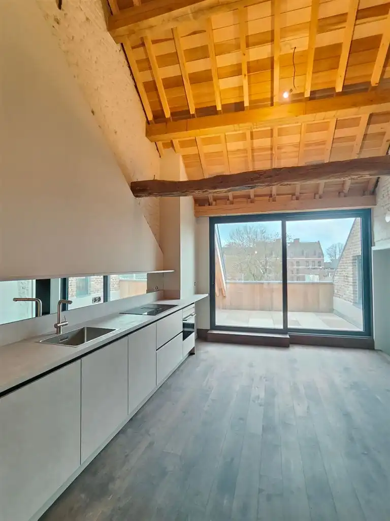 Luxe duplex loft op de tweede verdieping met 2(+1) slaapkamers, ruim terras en optioneel een staanplaats, gelegen in het centrum van Maaseik. foto {{pictureIndex}}