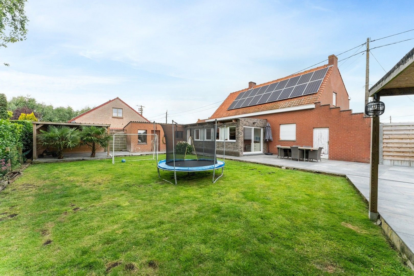 Hoofdfoto van de publicatie: Ruime open bebouwing, grotendeels gerenoveerd, met grote carport, terrassen en tuin