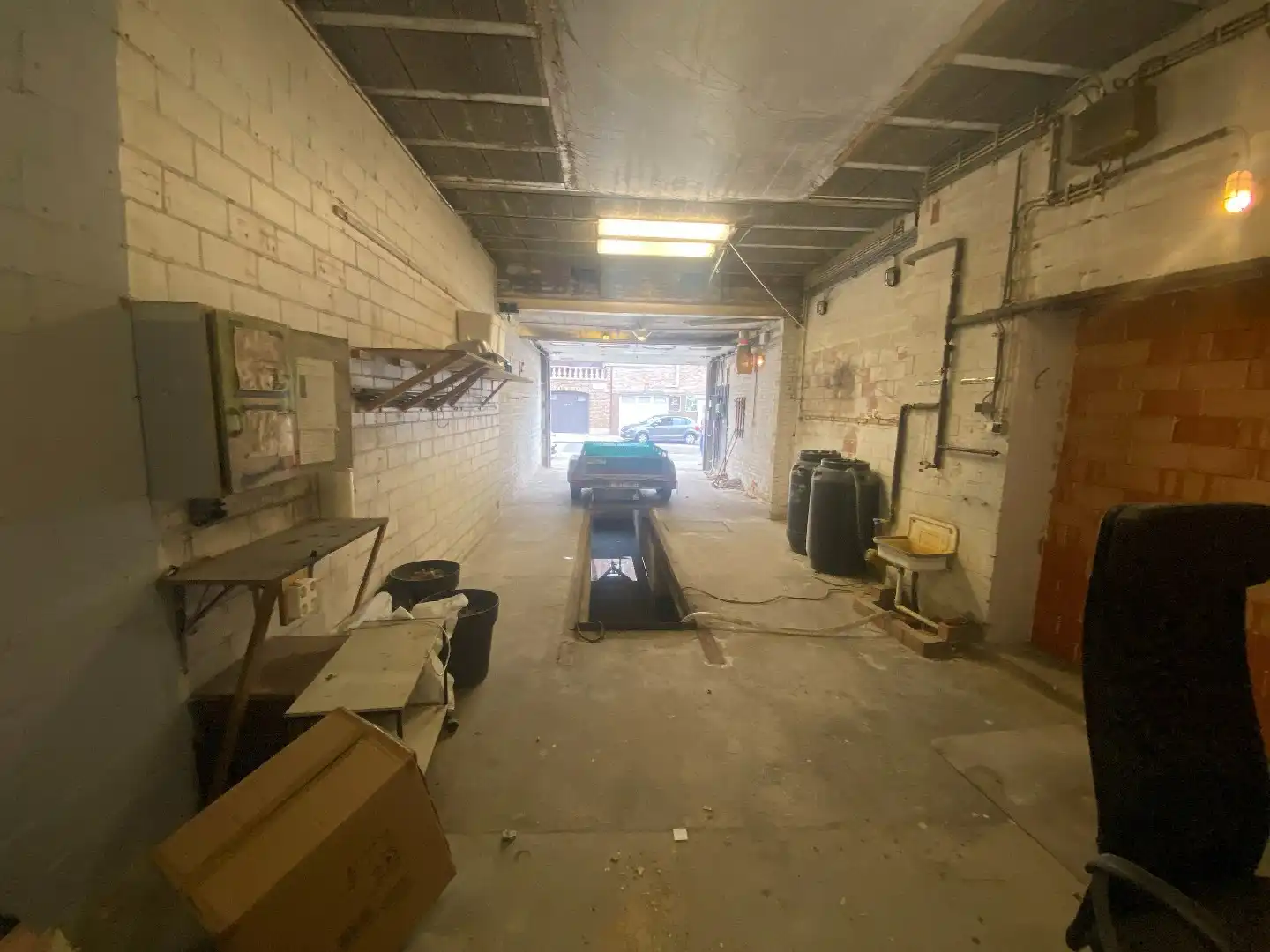 Ruime garage/magazijn met smeerput en elektrische poort foto 3