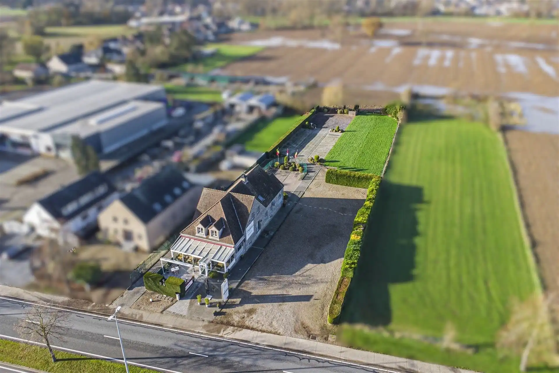 Commercieel bedrijfspand met woonst langs de Rijksweg in Maasmechelen, met hoge visibiliteit, parkeermogelijkheden en veelzijdig commercieel potentieel! foto {{pictureIndex}}