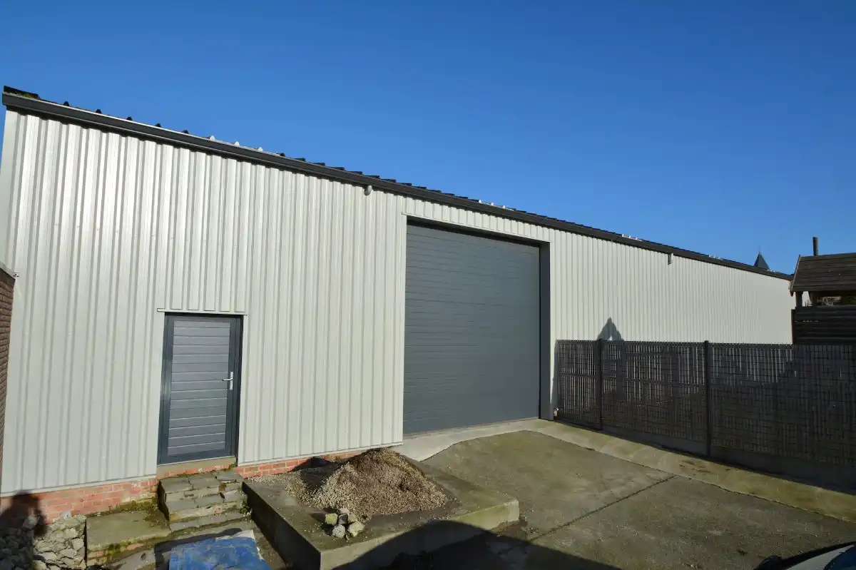 OPSLAGRUIMTE (430m²) TE HUUR met geïsoleerd dak, hoge elektrische sectionaalpoort en BUREEL te Oostkamp (Hertsberge). Op 4km van E40. foto {{pictureIndex}}