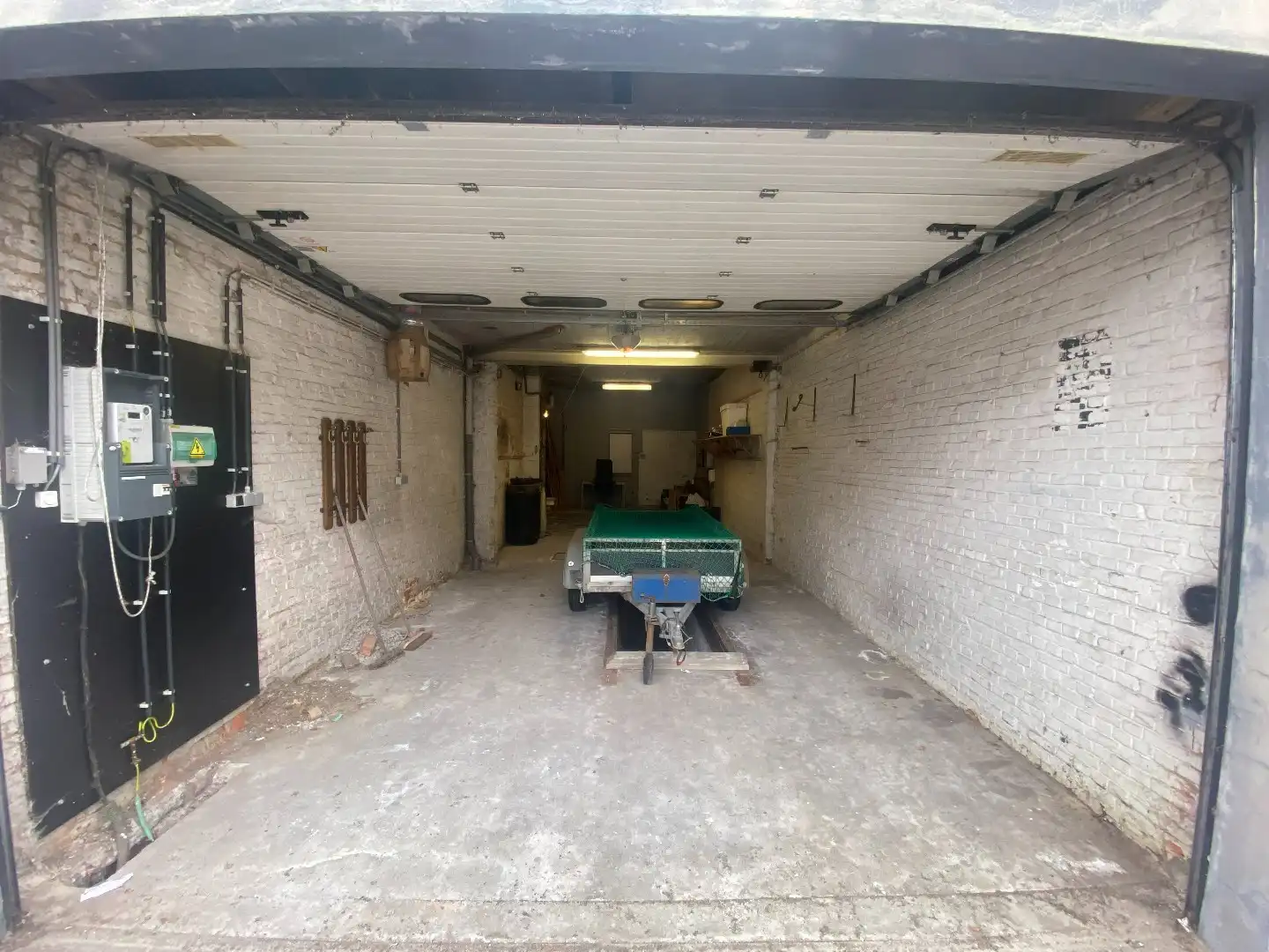Ruime garage/magazijn met smeerput en elektrische poort foto 2