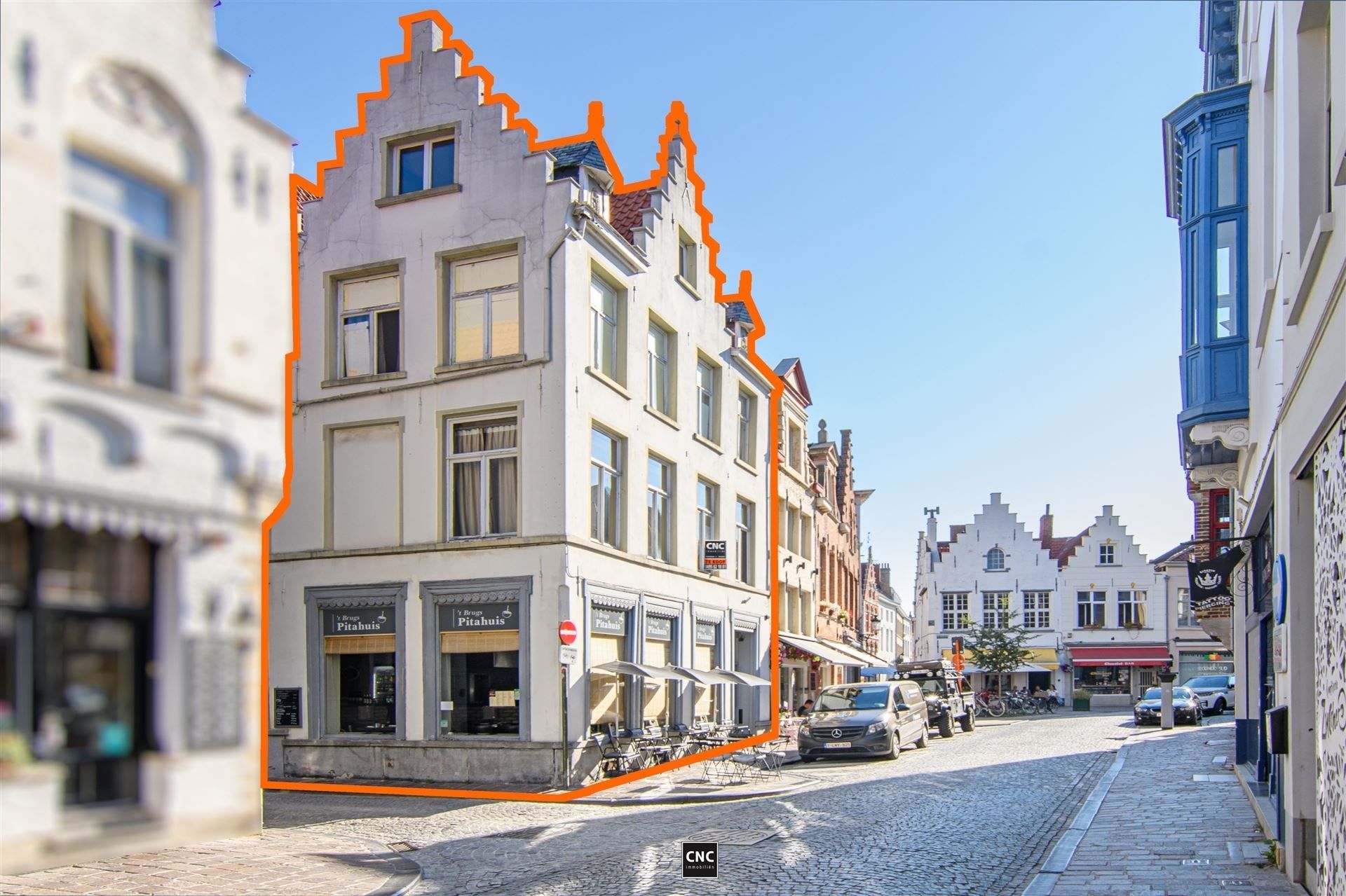 Handelspand met woonst op een commerciële en toeristische goede ligging, op wandelafstand van de Grote Markt en de Burg, in de schaduw van het Belfort, Het Provinciaal Hof en het stadhuis, met brede gevel en goede zichtbaarheid door zijn hoekligging. foto {{pictureIndex}}