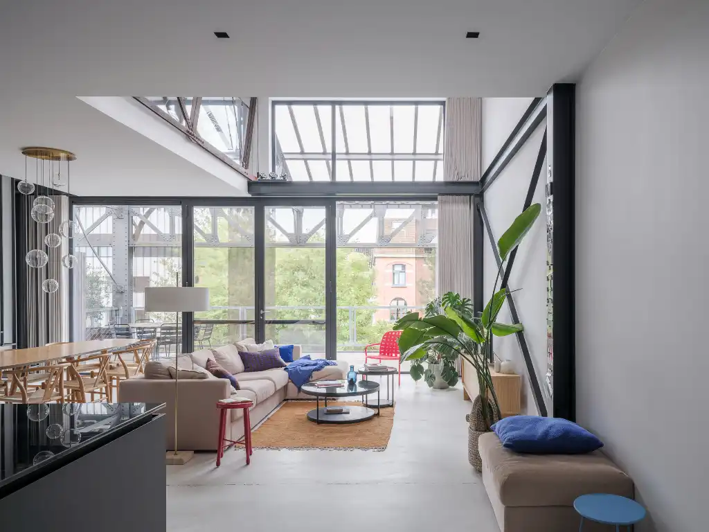 Luxueus en tijdloos – Exceptionele loft met 2 slaapkamers, aparte bureauruimte en ruim terras in een beschermd gebouw met een rijke industriële voorgeschiedenis. foto {{pictureIndex}}