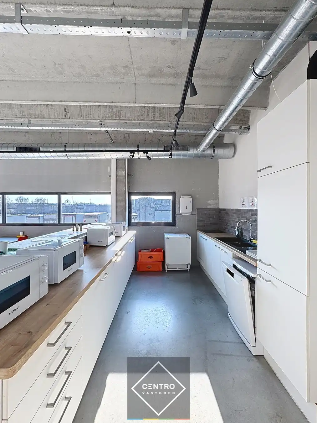 Goed geïsoleerd en verwarmd BEDRIJFSGEBOUW, bestaande uit MAGAZIJNEN (1.080m²) met KANTOREN en randaccomodatie (999m²) en 40-tal private parkeerplaatsen op het terrein. Vlak aan de afrit Zandvoorde (Oostende). foto 11
