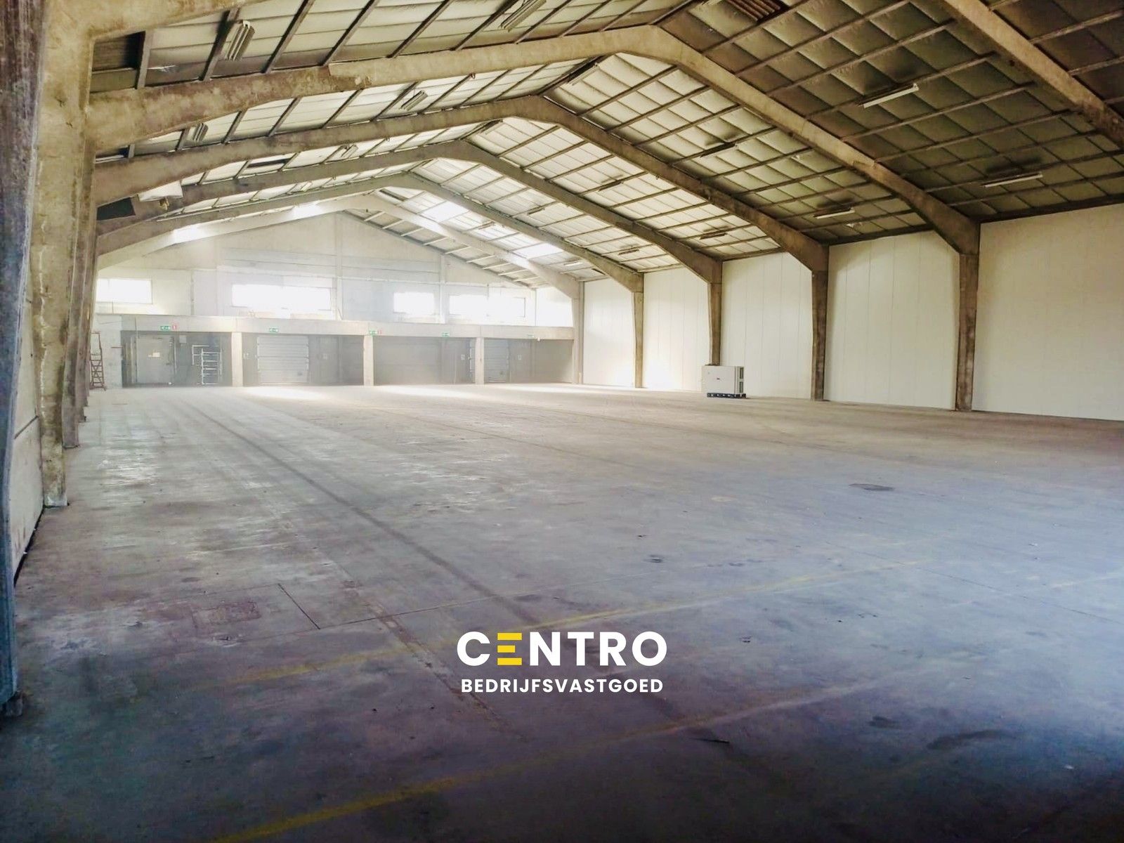 Instapklaar MAGAZIJN (1.200m²), voorzien van 2 LAADKADEN (met levellers), elektrische sectionaalpoort en verhard terrein (voor- en achterkant) op industriezone te Gistel. foto {{pictureIndex}}