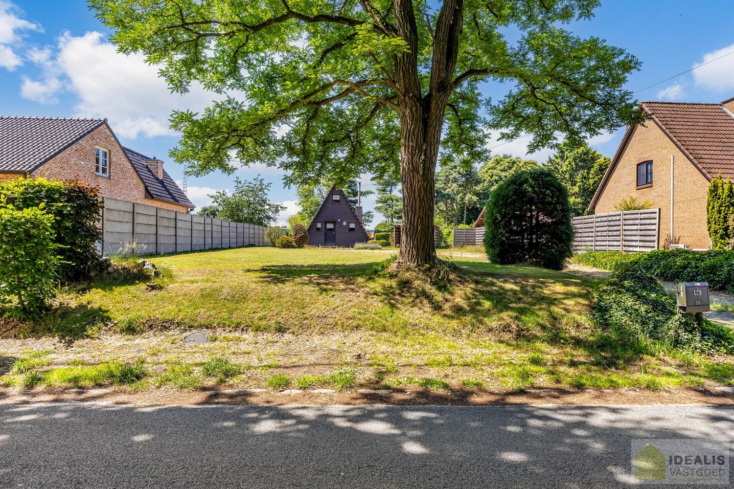 DEALIS VASTGOED – Residentieel gelegen bouwgrond met zicht op groen van maar liefst 12a (1200m²) met een straatbreedte van +- 20m. Momenteel voorzien van een chalet (onvergund) die dienst kan doen als tijdelijke woning. foto {{pictureIndex}}