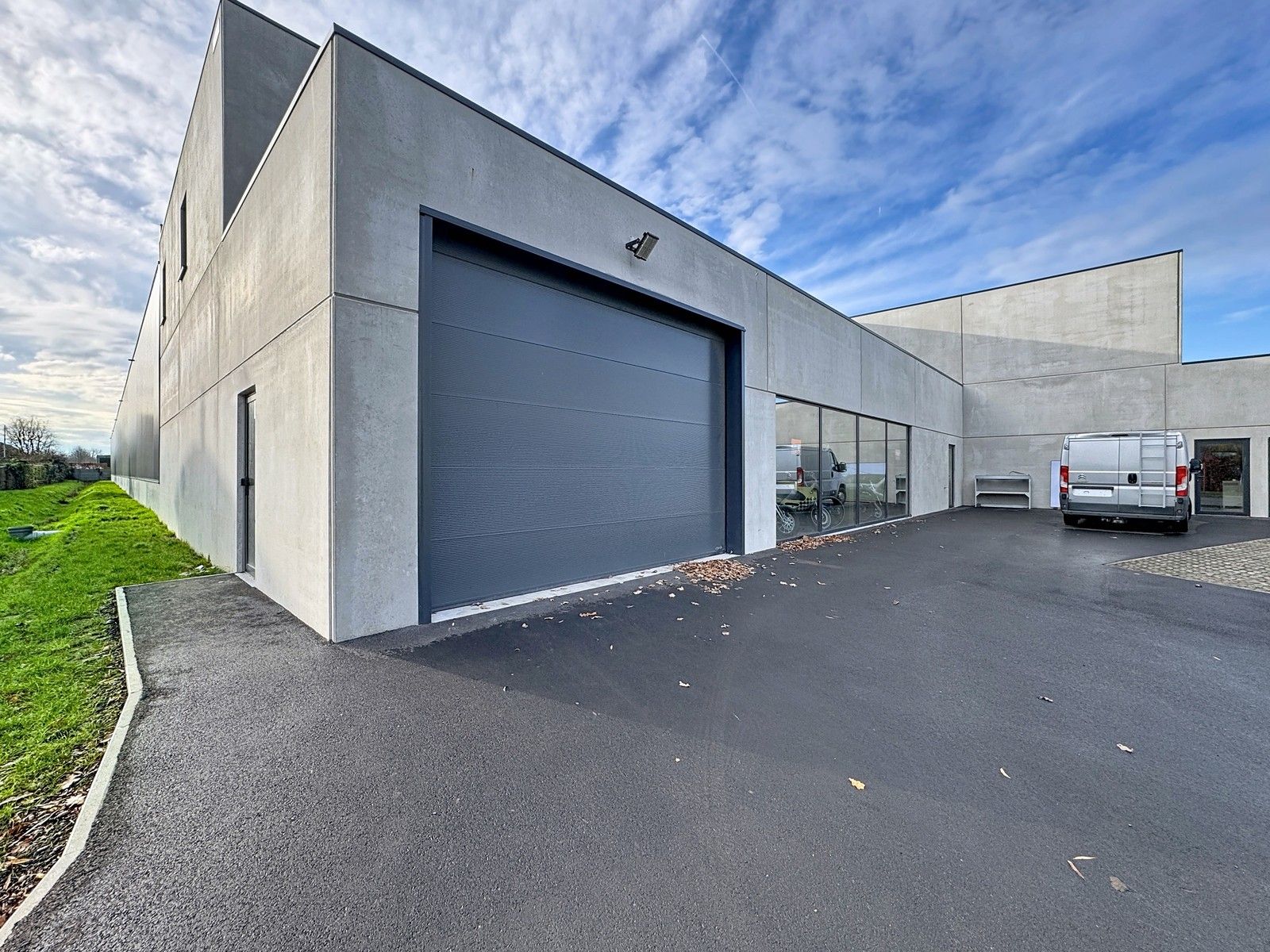 NB BEDRIJFSPAND bestaande uit MAGAZIJN met TOONZAAL/BURELEN en casco LOFT-APPARTEMENT met groot TERRAS. Op ambachtelijke zone "Schatting" te Zedelgem foto {{pictureIndex}}