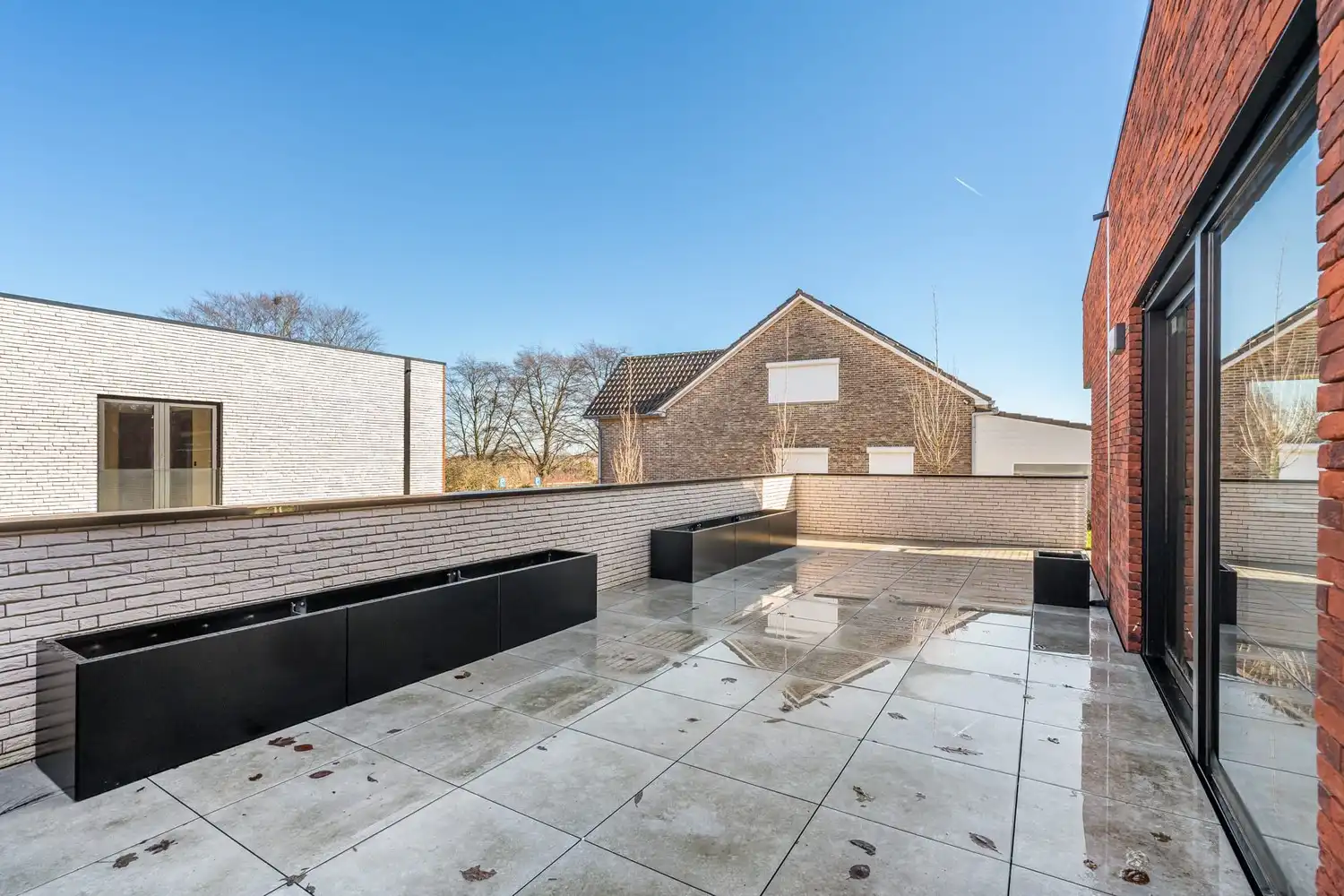 Deze stijlvolle nieuwbouw rijwoning in de Kanunnik Darisstraat combineert een centrale ligging in het hart van Borgloon met hedendaags wooncomfort en energiezuinige technieken. Met winkels, horeca en andere voorzieningen op wandelafstand woon je hier rustig én praktisch.  De woning is verdeeld over twee verdiepen en biedt een doordachte, gezinsvriendelijke indeling. Op het gelijkvloers bevindt zich een gezellige leefruimte met warme parketvloer, die naadloos aansluit op de volledig ingerichte leefkeuken met kookeiland – de ideale plek om te koken, te tafelen en gasten te ontvangen in een aangename, open sfeer.  Op de verdieping zijn er drie volwaardige slaapkamers, waardoor deze woning ideaal is voor gezinnen, koppels die extra ruimte wensen of wie een aparte bureau‑ of hobbykamer zoekt. De stijlvol afgewerkte badkamer, met kwalitatief badkamermeubel, ruime inloopdouche en moderne zwarte accenten, zorgt elke dag opnieuw voor een echt wellnessgevoel.  Buiten geniet je van een... foto 10