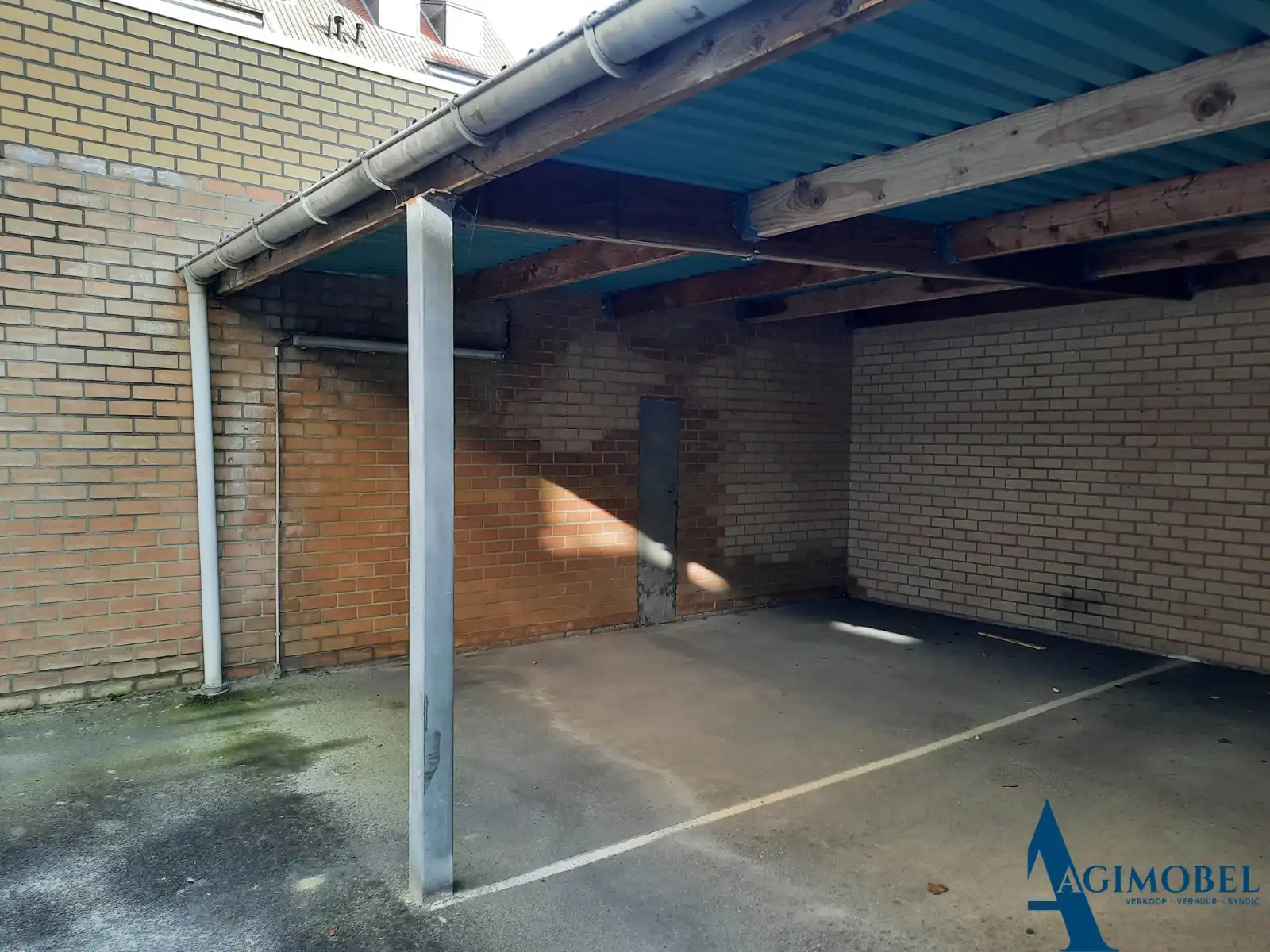 Overdekte staanplaats gelijkvloers links tegen muur, gelegen op  de Koningslaan. foto 2