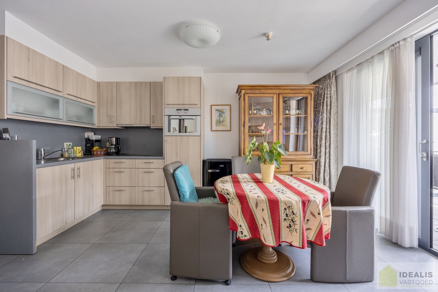 IDEALIS VASTGOED – HOOGWAARDIG AFGEWERKTE ASSISTENTIE-APPARTEMENT IN RESIDENTIE NUMA OP EEN TOPLOCATIE. Gelegen op de 2de verdieping met een bewoonbare oppervlakte van ca. 60m² biedt dit knappe assistentie-appartement een aangename leefruimte met aansluitend een zonnig overdekt terras, uitgeruste keuken en een ruime slaapkamer met veel lichtinval! Daarnaast kan er gebruik gemaakt worden van de talrijke gemeenschappelijke ruimtes en kan men aangenaam vertoeven in de prachtige gemeenschappelijke tuin, een oase van rust! foto 5