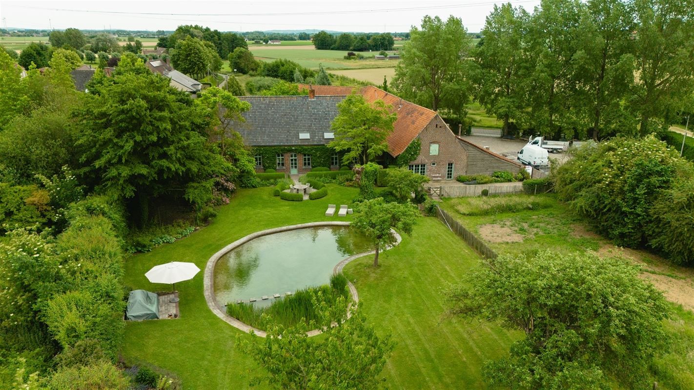 Hoofdfoto van de publicatie: Charmante hoeve met loods en idyllische tuin te koop in Zwevegem