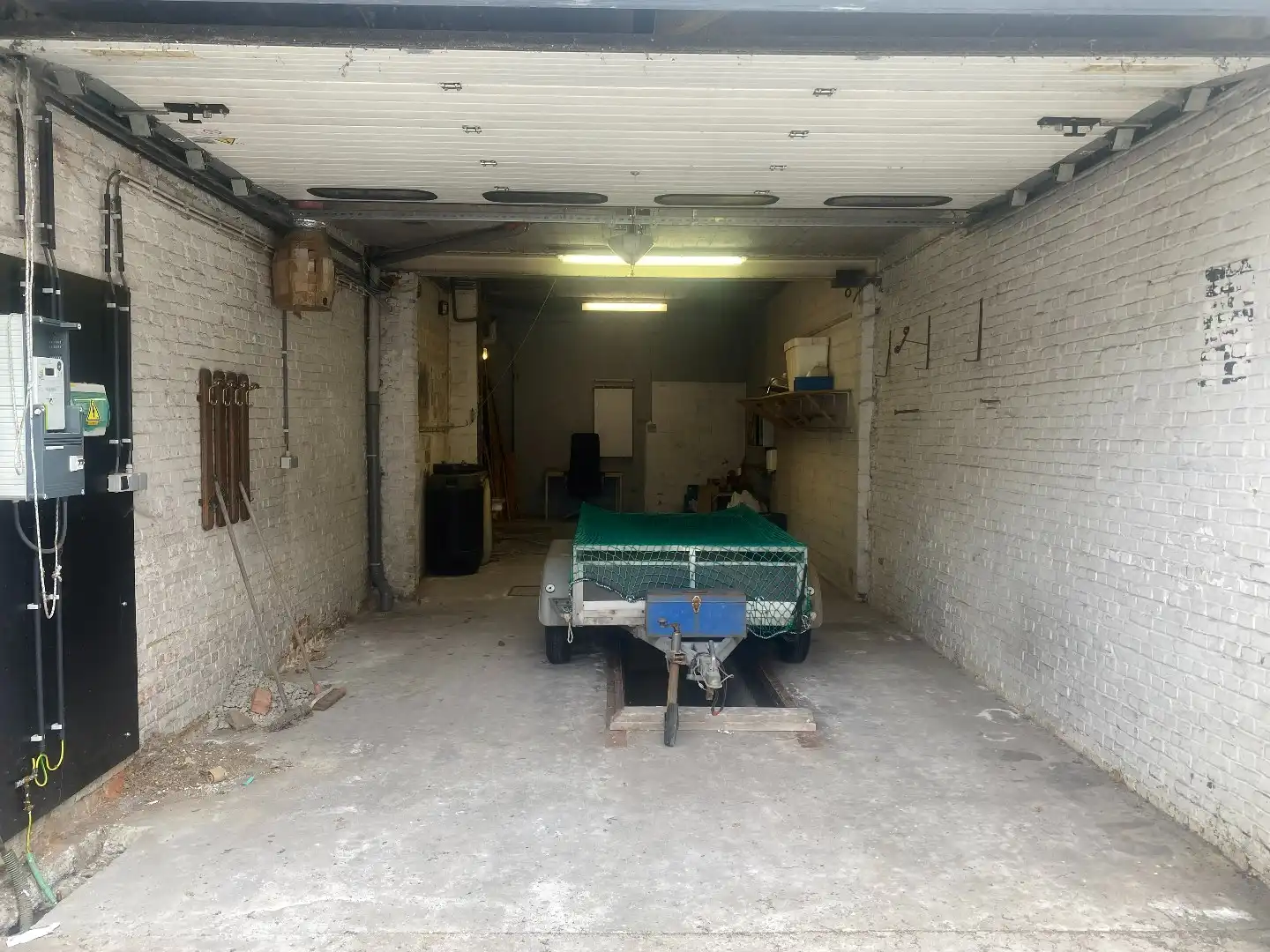 Ruime garage/magazijn met smeerput en elektrische poort foto 3