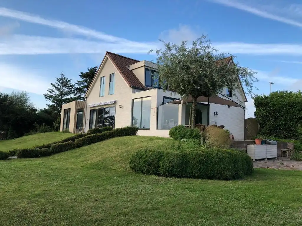 Zicht over de velden, op een zucht van zee foto {{pictureIndex}}