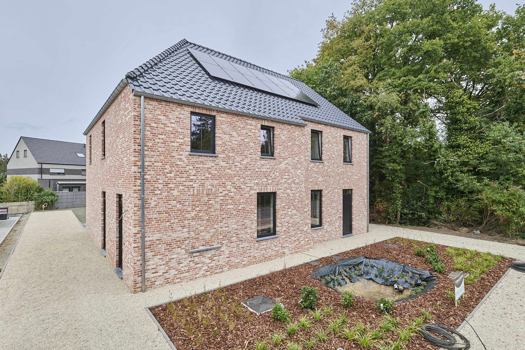 Nieuwbouwwoning in pastorijstijl met aangelegde tuin foto {{pictureIndex}}