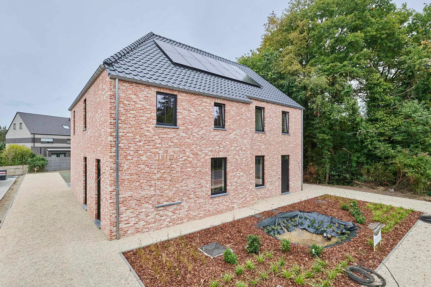 Nieuwbouwwoning in pastorijstijl met aangelegde tuin foto {{pictureIndex}}