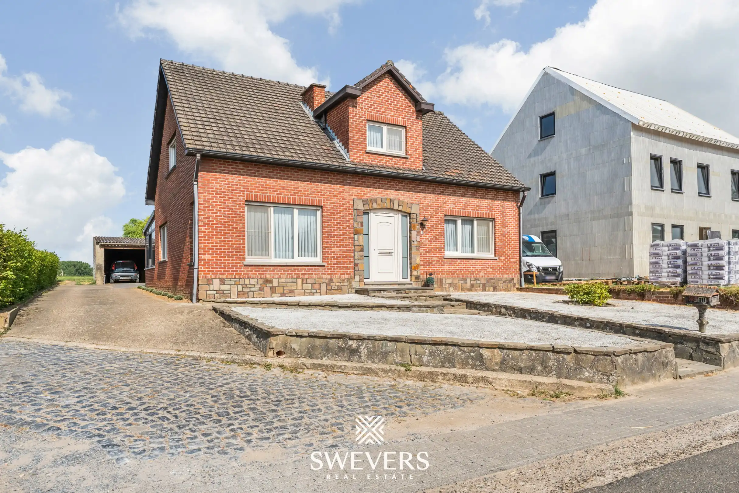 Hoofdfoto van de publicatie: Ruime open bebouwing met 4 slaapkamers, grote garage en zonnig perceel van 15 are 28 ca